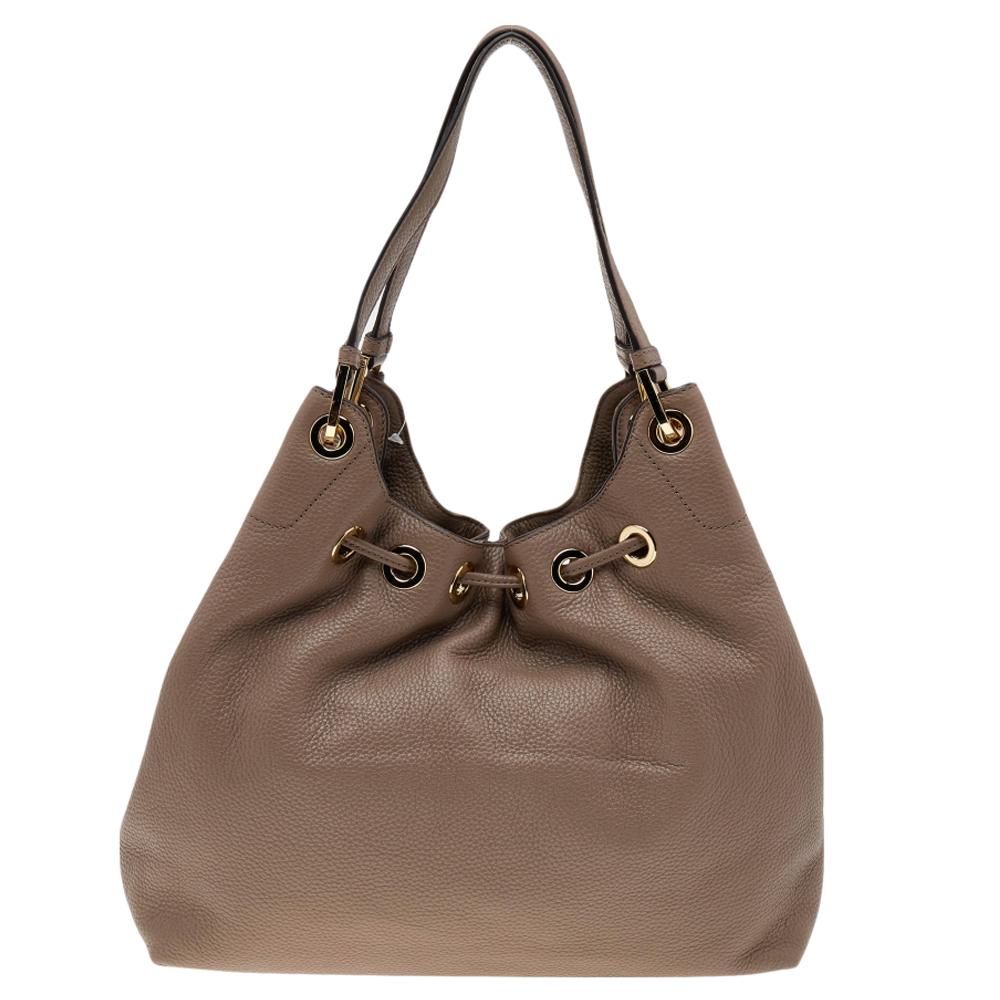Die zeitlos eleganten und stilvollen Kollektionen von Michael Kors fangen die mühelose, lässige Finesse der modernen Frau ein. Diese schicke Tasche aus braunem Leder verfügt über einen mit Quasten verzierten Kordelzugverschluss, der zu einem