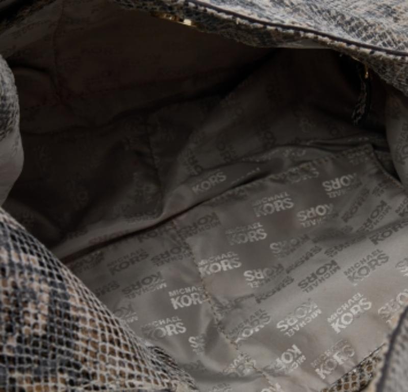 Un savoir-faire immaculé et un style classique, voilà ce qu'offre ce hobo en cuir python gaufré fabuleusement travaillé. L'intérieur est doublé de tissu et le sac est doté d'une poignée unique. Ce sac marron de la maison MICHAEL Michael Kors est