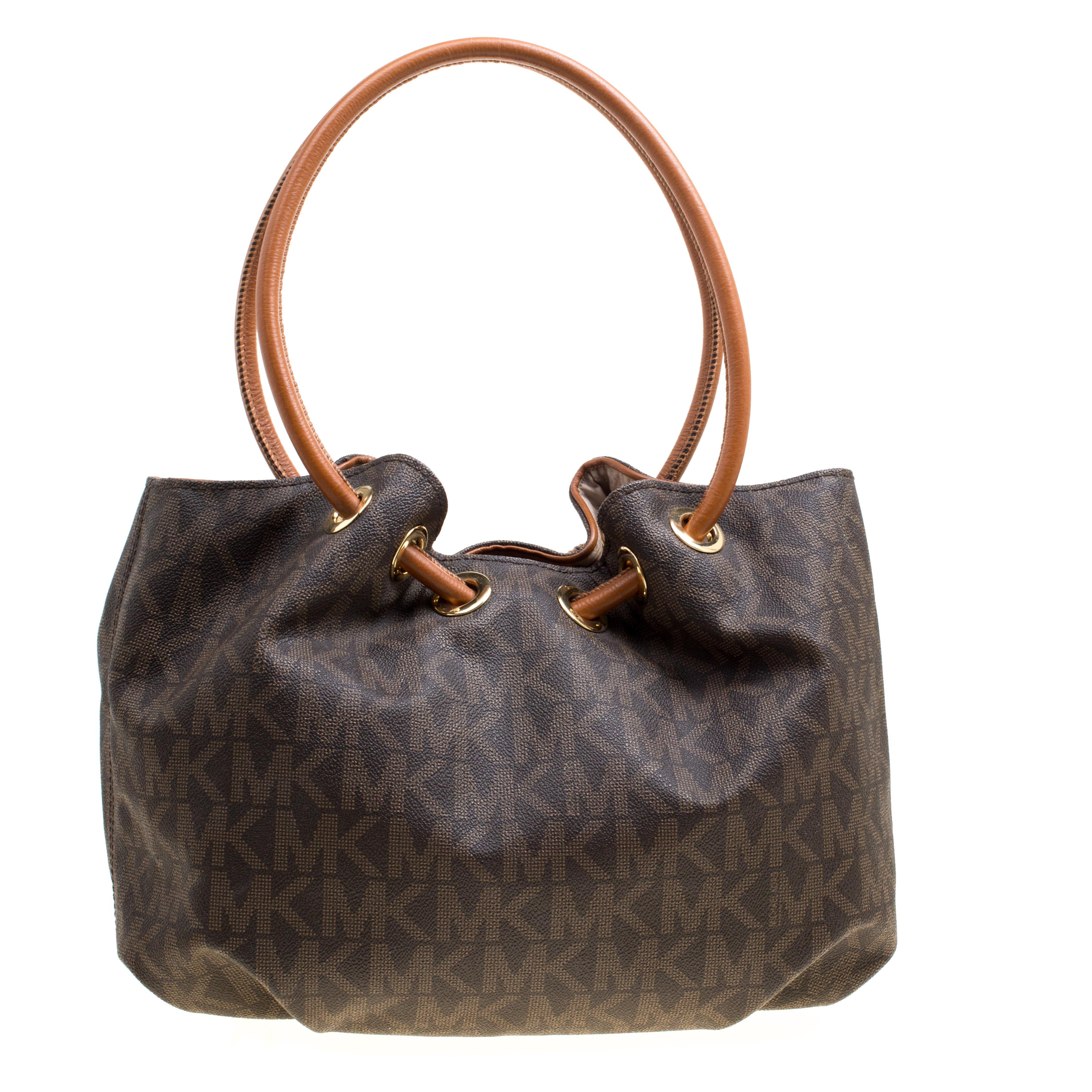 Look polished and sophisticated while you carry this Michael Kors bag. This signature coated canvas and leather bag is sturdy and can hold all your essentials. It is held by ring handles and finished with a spacious fabric interior.

Includes: The