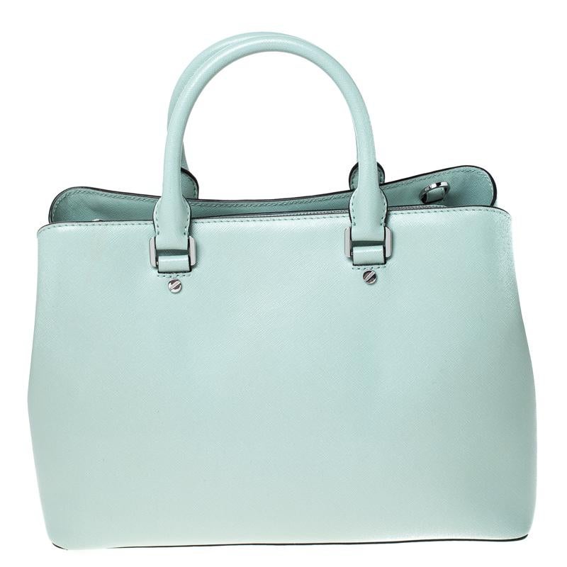 Stunning to look at and durable enough to accompany you wherever you go, this Michael Kors Savannah Celadon tote is a joy to own! This bag is crafted from leather and held by two handles and a shoulder strap. The insides are nylon lined and