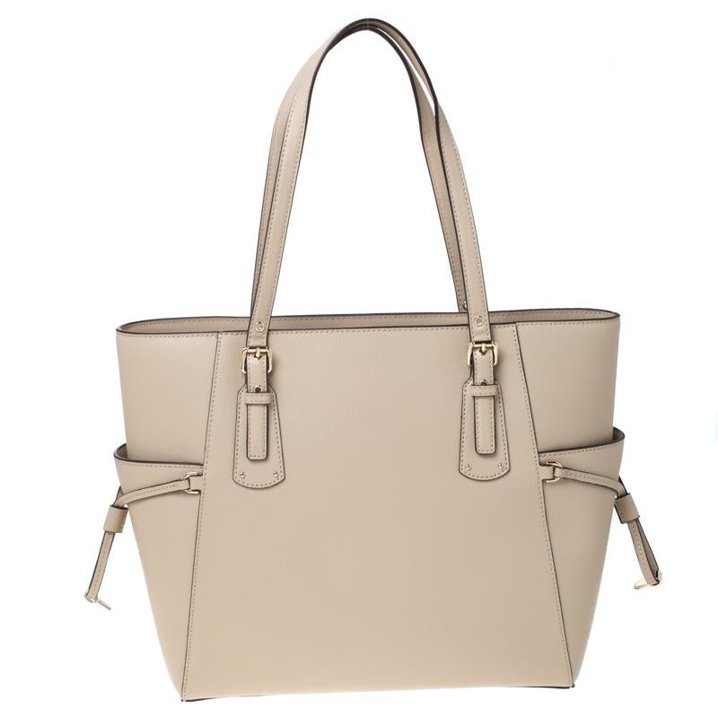 This Michael Kors tote is beautiful in so many ways. From its design to its structure, the leather bag exudes charm and high fashion. It flaunts two shoulder handles for you to swing and a spacious fabric interior to hold all your