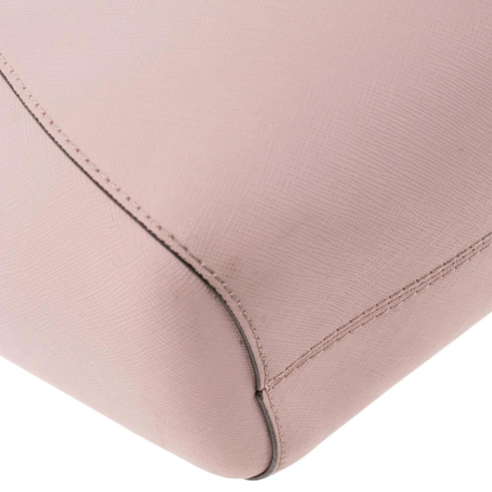Diese MICHAEL Michael Kors Tragetasche ist auf so viele Arten schön. Die rosa Saffiano-Ledertasche besticht durch ihr Design und ihre Struktur und bietet Charme und Funktion. Er verfügt über zwei Schultergriffe zum Schwenken und eine geräumige