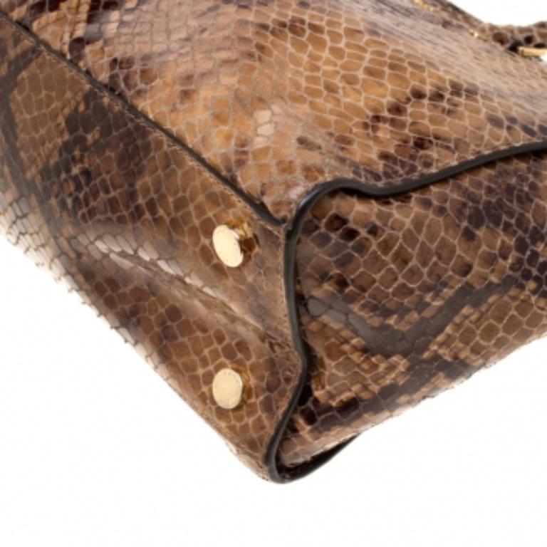 Make everyone nod in approval when you step out swaying this classy Michael Kors Selma tote. It has been crafted from python-embossed leather and it is held by twin top handles. The bag has a well-sized fabric interior and it is perfectly made whole