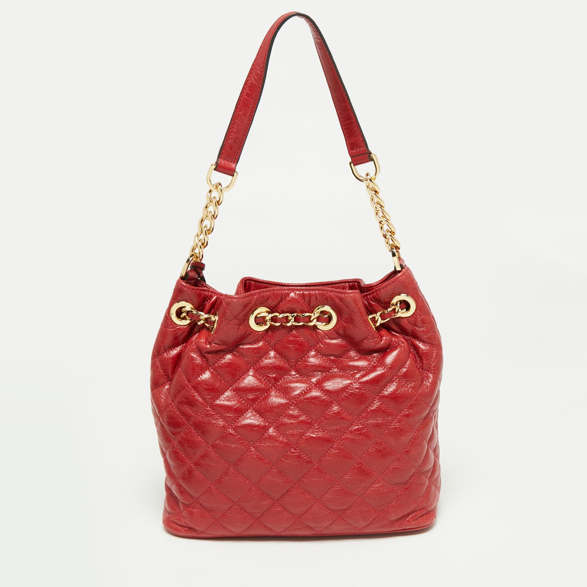 This MICHAEL Michael Kors bag is timeless yet immediately distinctive. Created from quilted leather, it displays a branded charm on the front, gold-tone hardware, and a handle. The chain-detailed drawstring closure elevates the red silhouette of the