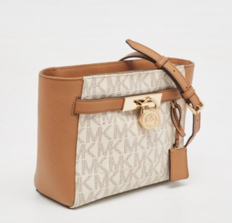 Ligera y duradera, esta bolsa MK es perfecta para el uso diario. Presenta un exterior de lona y cuero con un detalle de candado en la parte delantera. Se completa con una correa para el hombro.