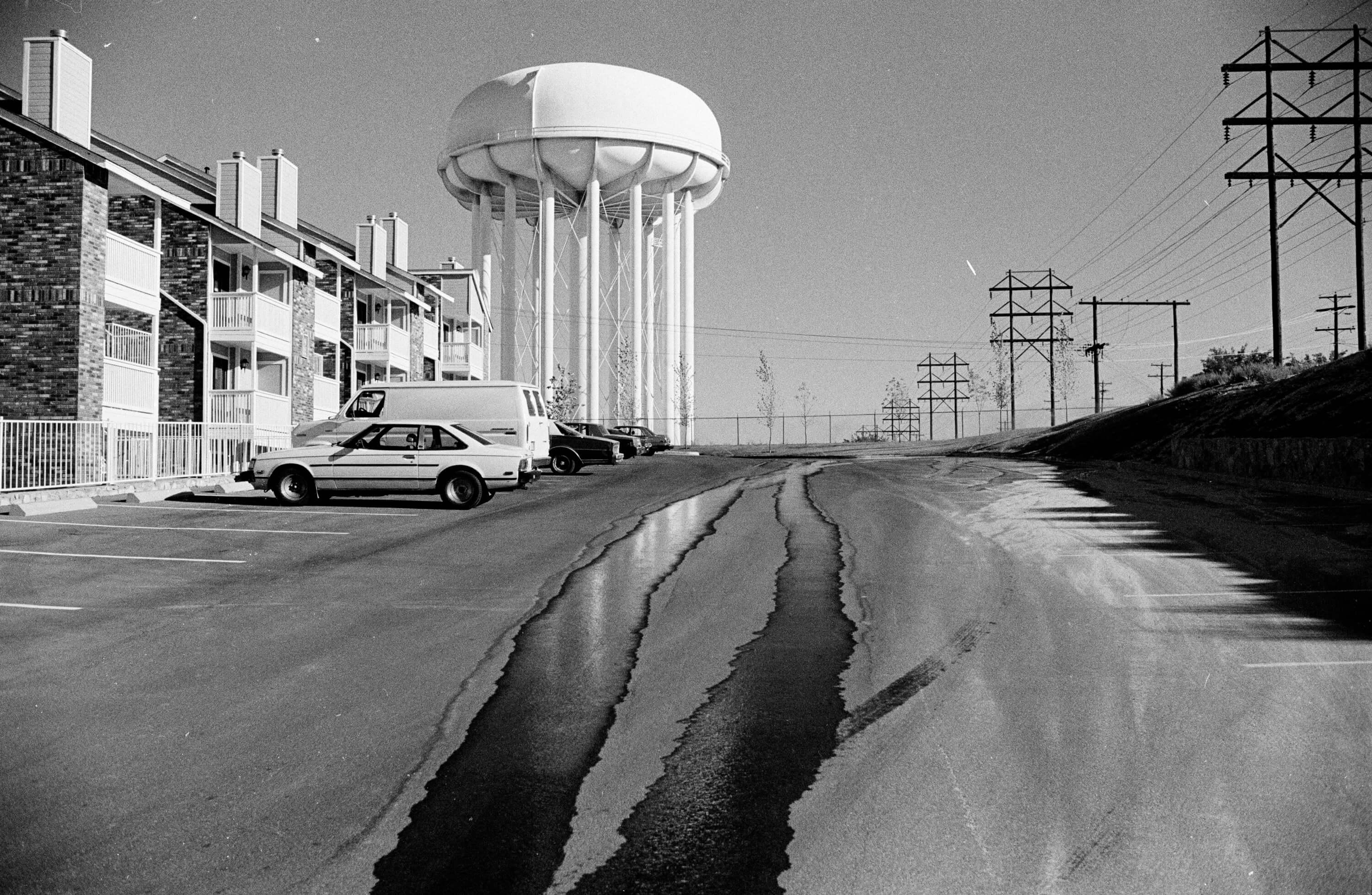 L'eau s'écoule dans une rue vide devant un château d'eau - Impression en noir et blanc