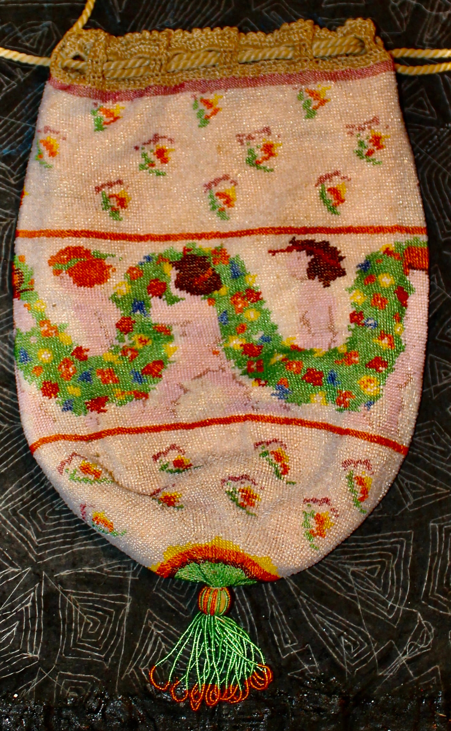 A fine beaded bag with Putties, wreaths and floral sprays on
a white field. Multi colored tassel. All in the Michael Powolny
Weiner Werstatte style.  9