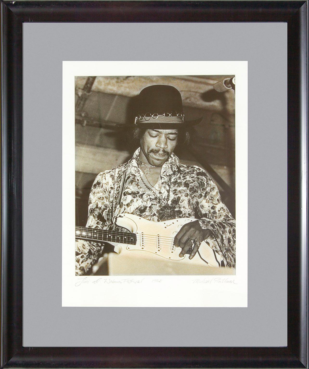 "Jimi at Woburn Festival 1968" photographie encadrée en noir et blanc de Michael Putland représentant Jimi Hendrix lors du festival de musique de Woburn en Angleterre le 6 juillet 1968. "Jimi at Woburn Festival 1968" écrit à la main au recto en bas