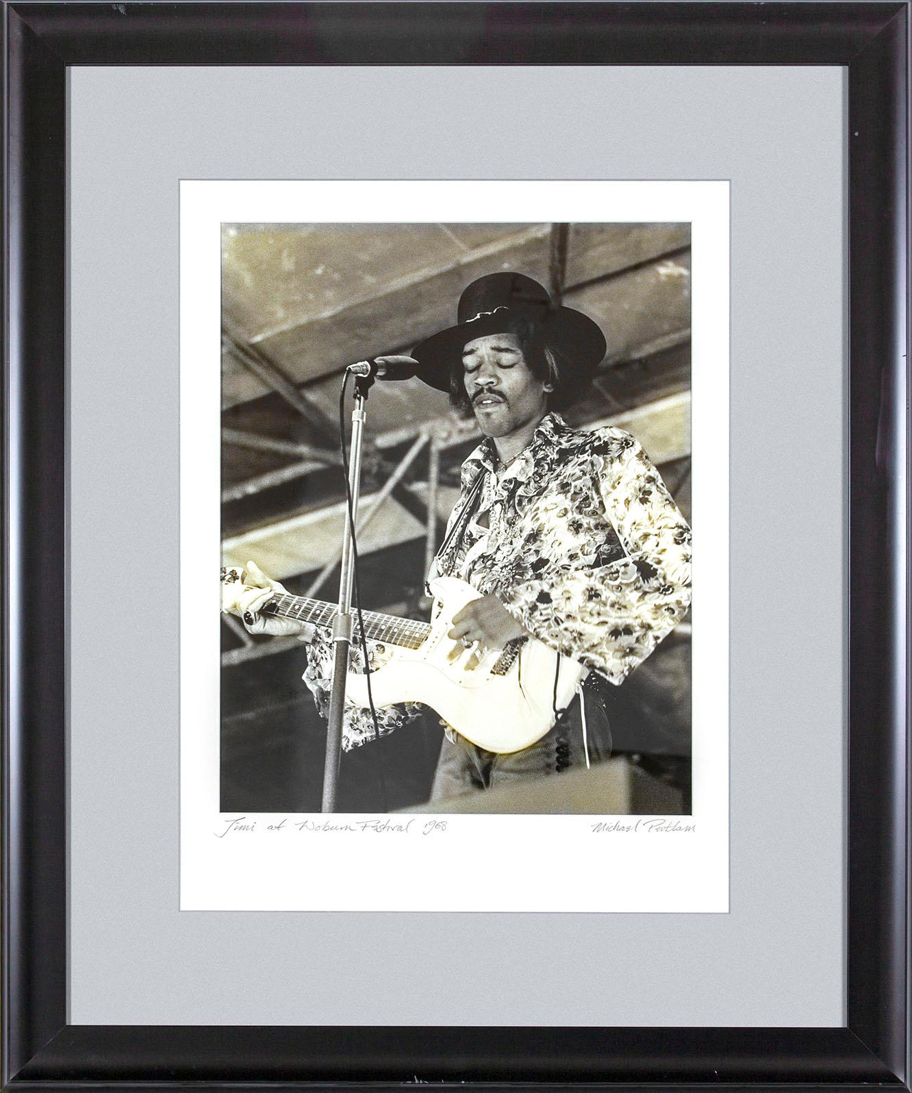"Jimi at Woburn Festival 1968" photographie encadrée en noir et blanc de Michael Putland représentant Jimi Hendrix lors du festival de musique de Woburn en Angleterre le 6 juillet 1968.  "Jim at Woburn Festival 1968" écrit à la main dans le coin