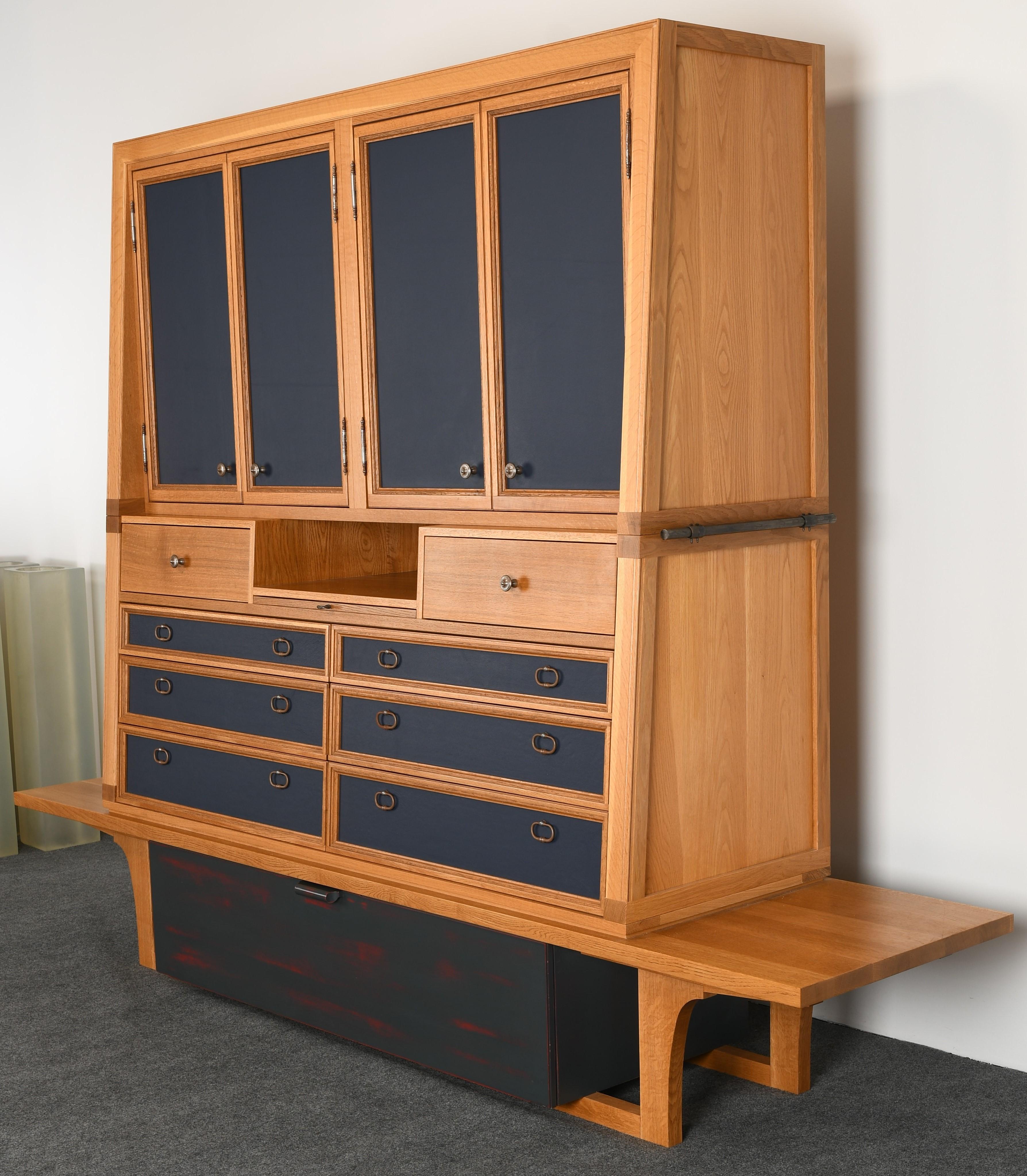 An exceptionally crafted custom made oak storage cabinets. Fitted with drawers and cupboard doors featuring blue leather fronts, bottom drawer has a decorative paint finish, each cabinet sold individually. These chest of drawers or wardrobes are