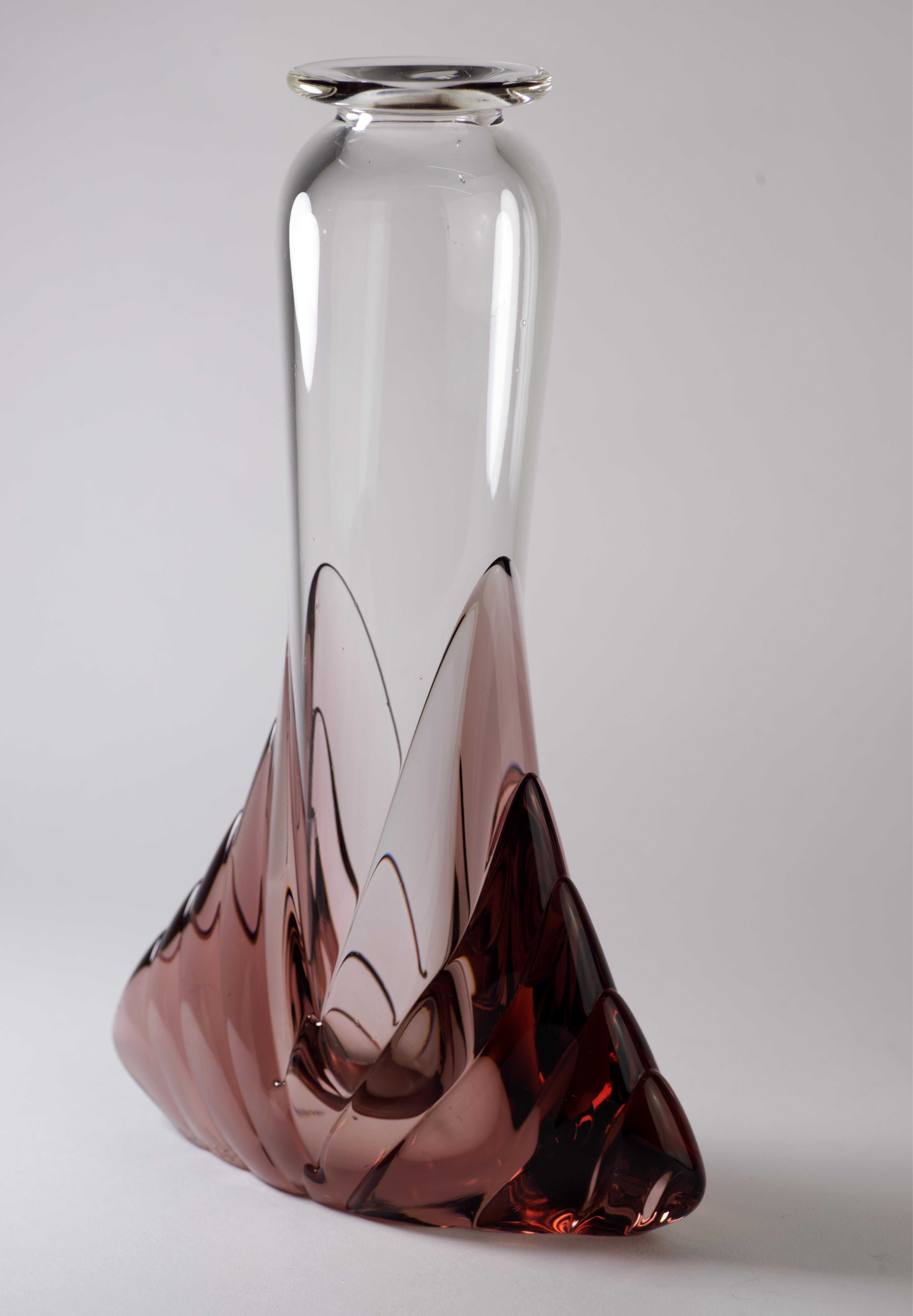  Il vaso scultoreo in stile Art Déco è stato soffiato a mano in vetro trasparente racchiuso nella base in vetro ametista. Il pezzo è firmato dall'artista su entrambi i lati del vaso, vicino alla parte inferiore, con la scritta 