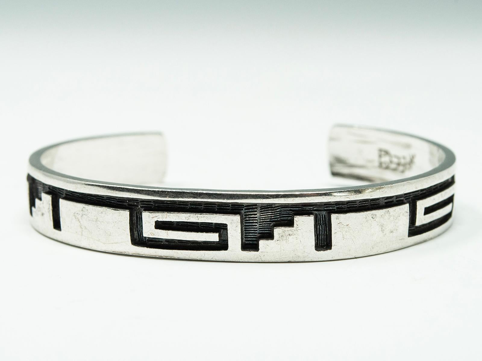 Hopi Artist, Michael Sockyma, Silver Overlay Bracelet

Well-known Hopi artist Michael Sockyma Sr. is from the Hopi village of Hotevilla and is a member of the Corn clan, which explains his hallmark image of an ear of corn. He has won multiple awards