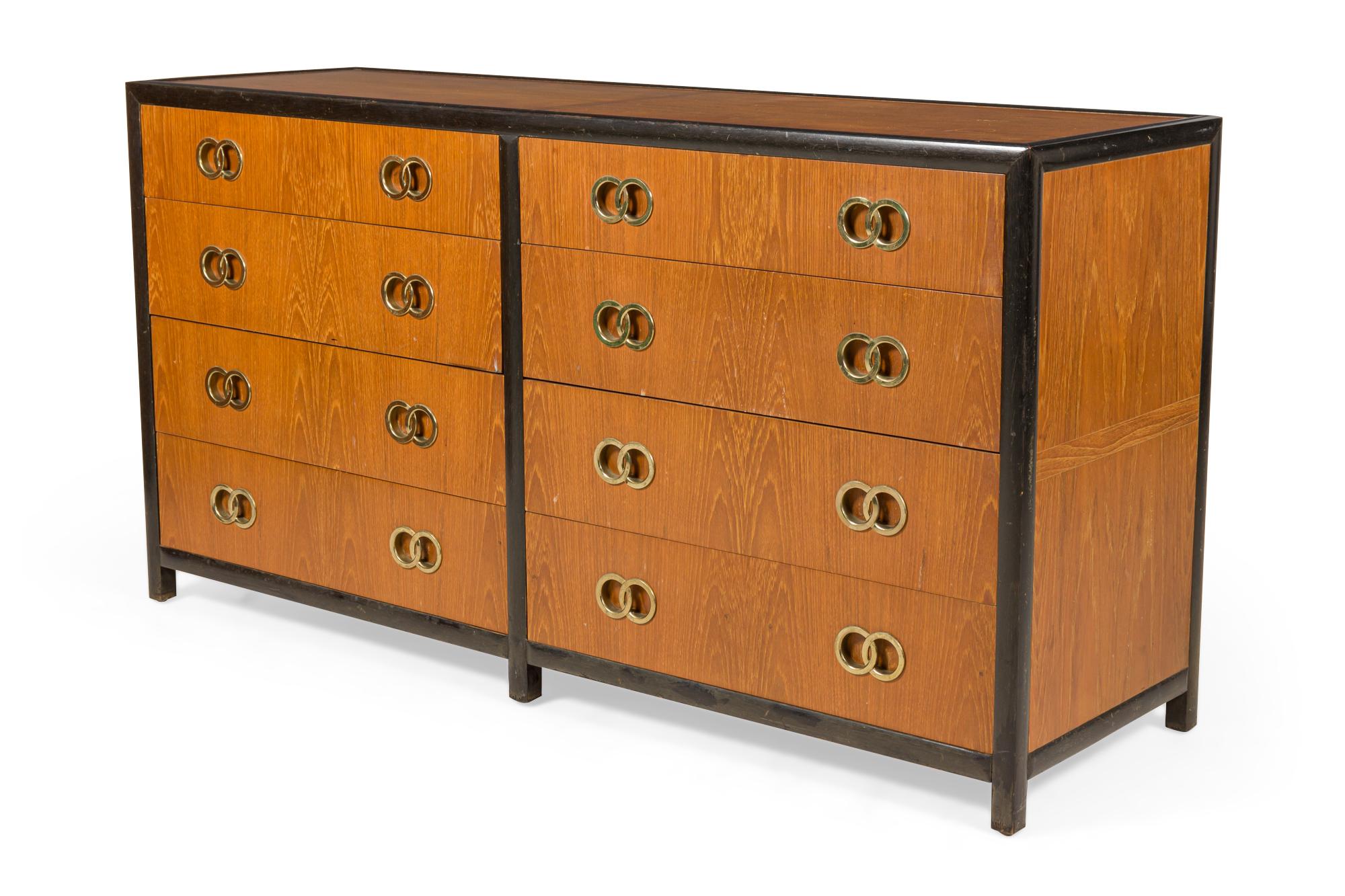 American Mid-Century 8-drawer low chest with dark stained trim, walnut drawer fronts and cabinet, and brass interlocking ring drawer pulls. (MICHAEL TAYLOR FOR BAKER FURNITURE CO.).
 