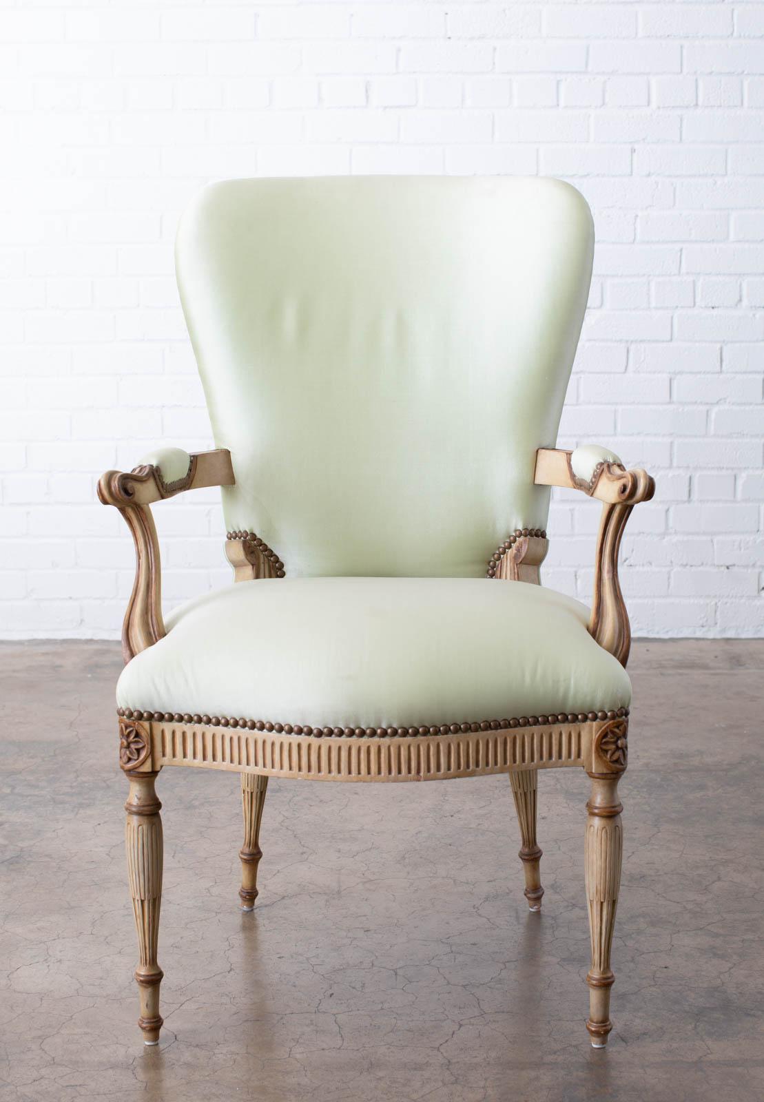 Handsome French style carved fauteuil armchair designed by Michael Taylor. Features a round barrel shaped back with subtle wings. The flat padded arms end with scrolls and gently curve down to the seat. The seat is decorated with rosettes on the