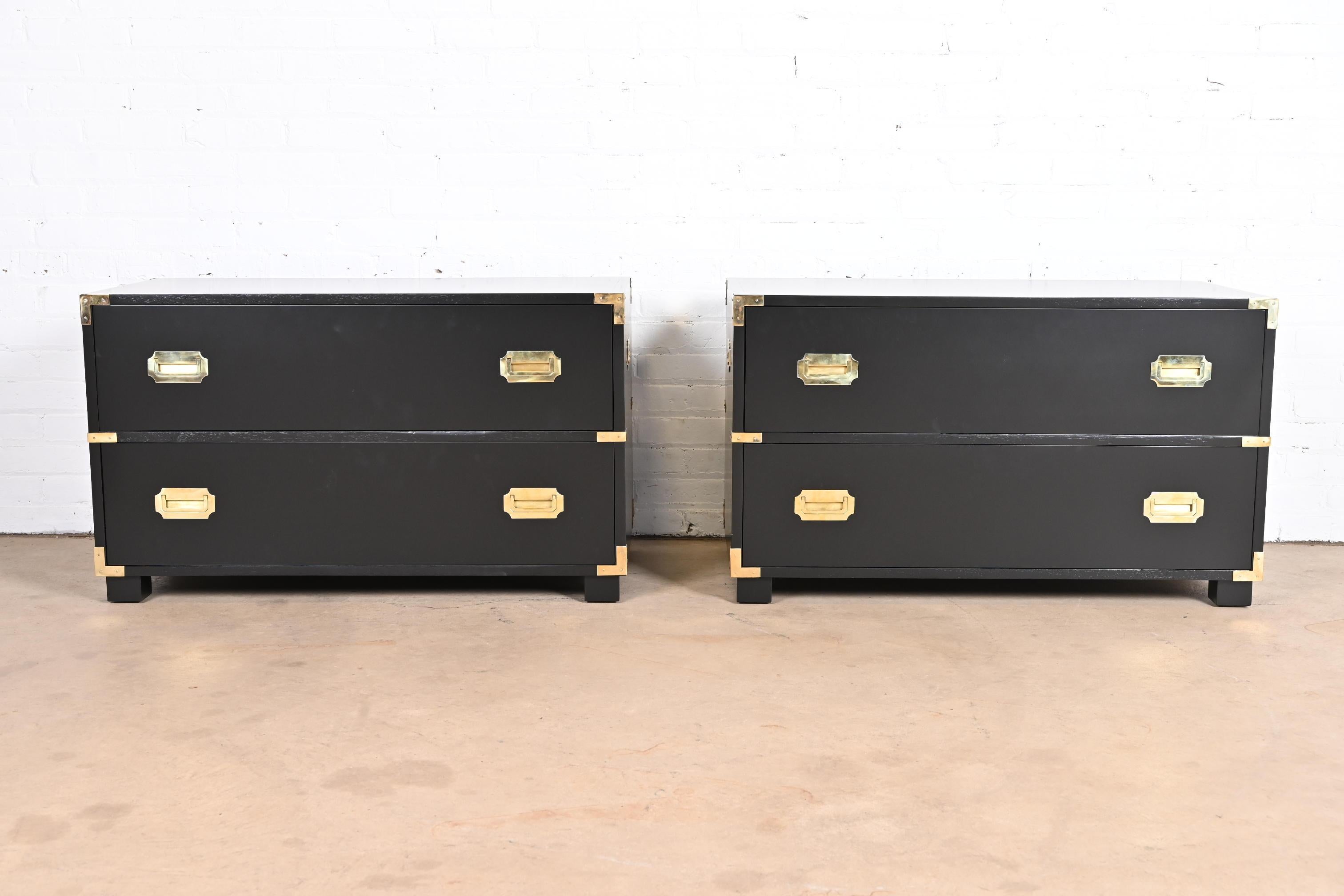 An exceptional pair of mid-century modern Hollywood Regency Campaign style two-drawer lowboy dressers or bedside chests of drawers

by Michael Taylor for Baker Furniture, 