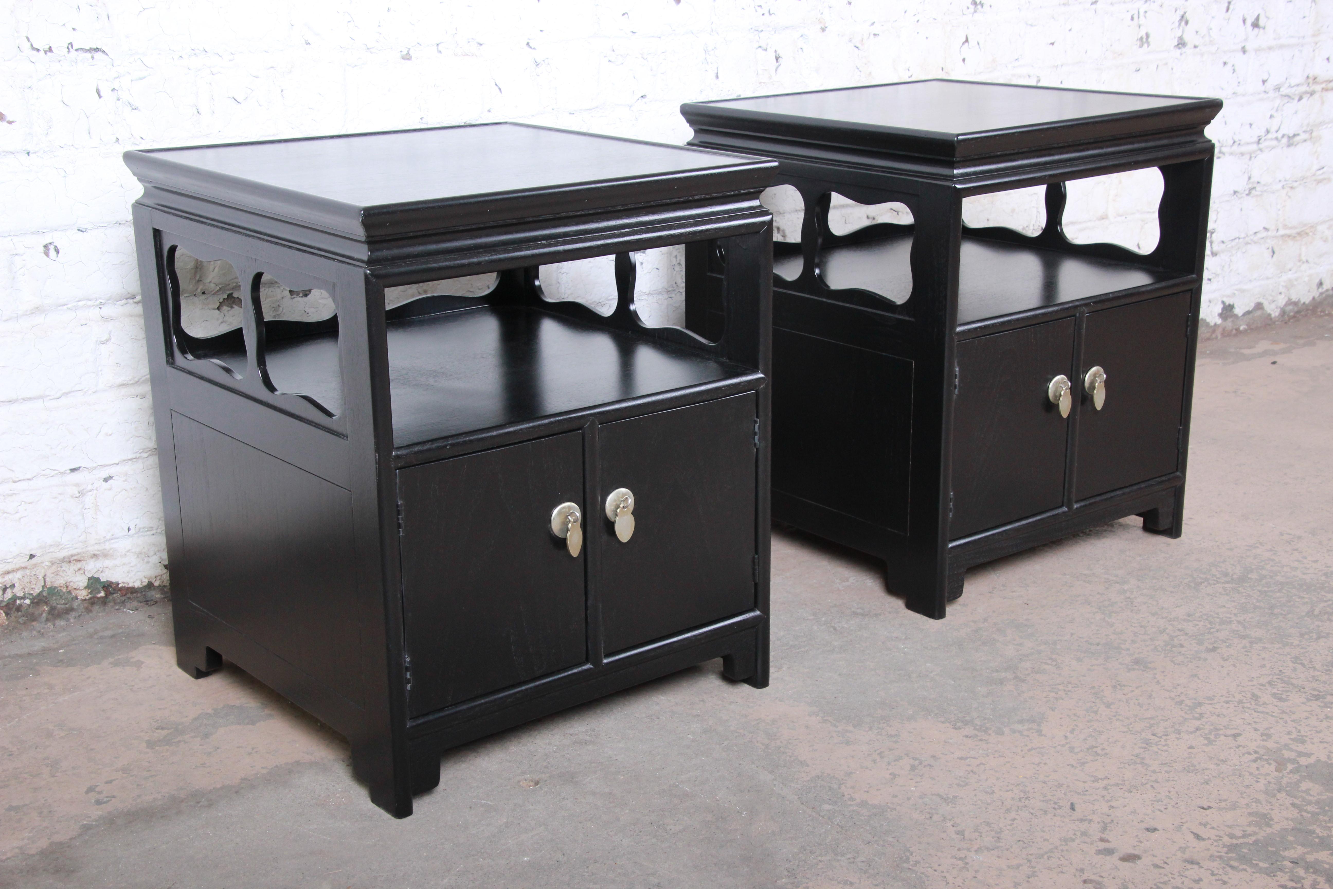 An exceptional pair of mid-century Hollywood Regency chinoiserie nightstands from the Far East Collection by Michael Taylor for Baker Furniture. The nightstands feature beautiful walnut wood grain in a newly ebonized finish and sleek Asian-inspired