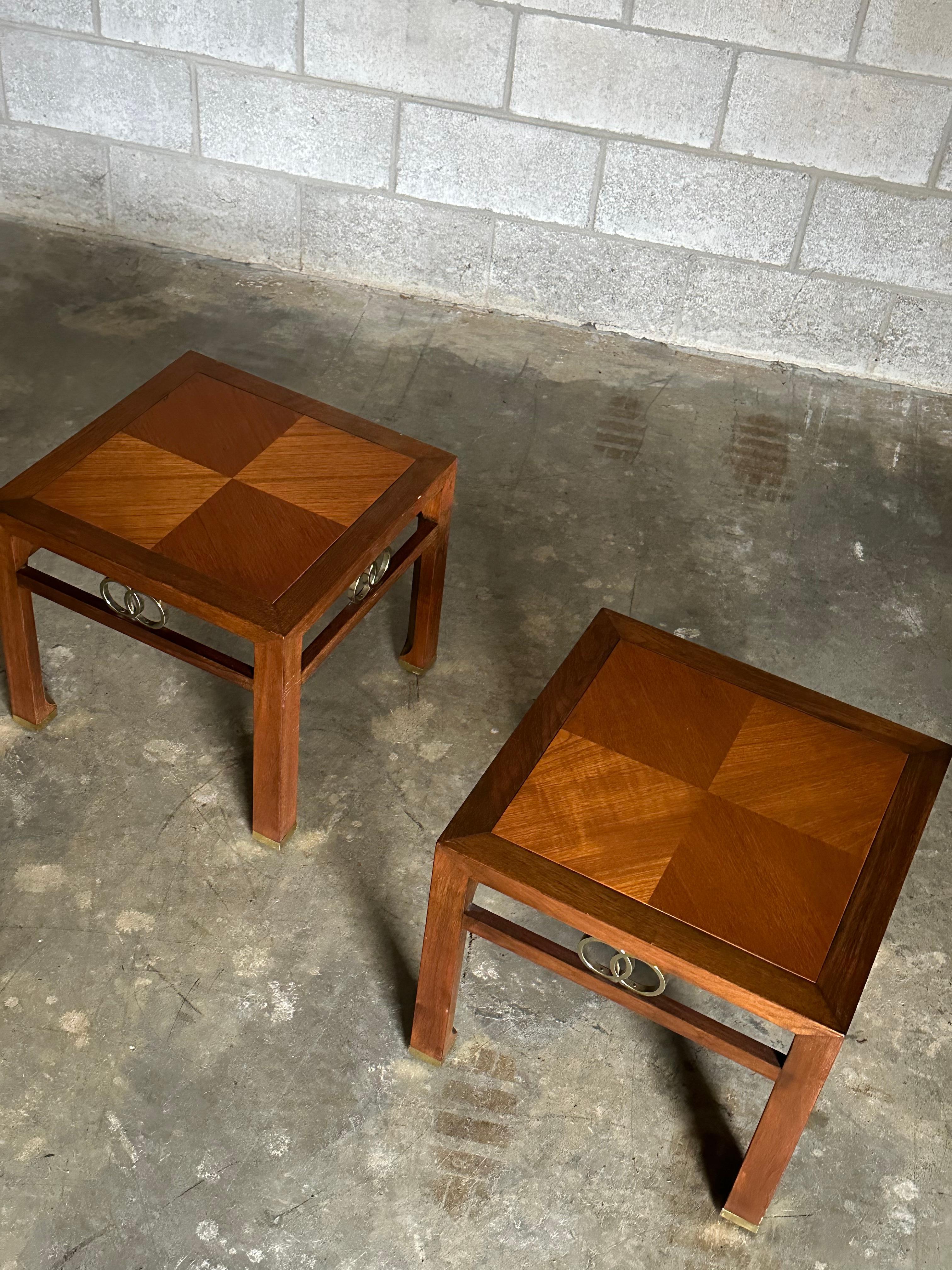 Gorgeous pair of side or end tables designed by Michael Taylor for Baker. Features a walnut frame, teak top in a checkered pattern, and brass accents to include feet and inter-lapping circles. Really nice details and craftsmanship as would be