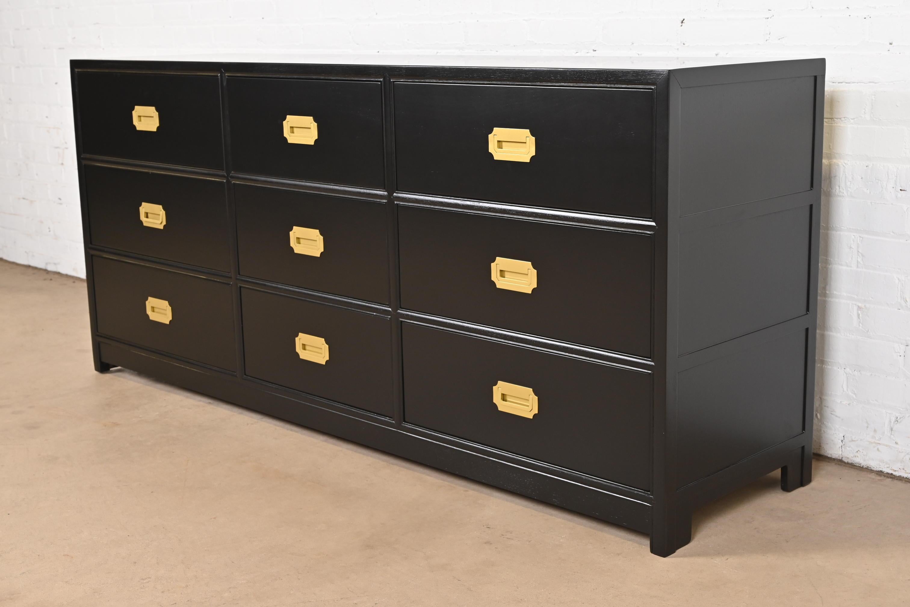 An exceptional mid-century modern Hollywood Regency Campaign style nine-drawer dresser or credenza

By Michael Taylor for Baker Furniture

USA, Circa 1960s

Black lacquered walnut, with original brass hardware.

Measures: 72