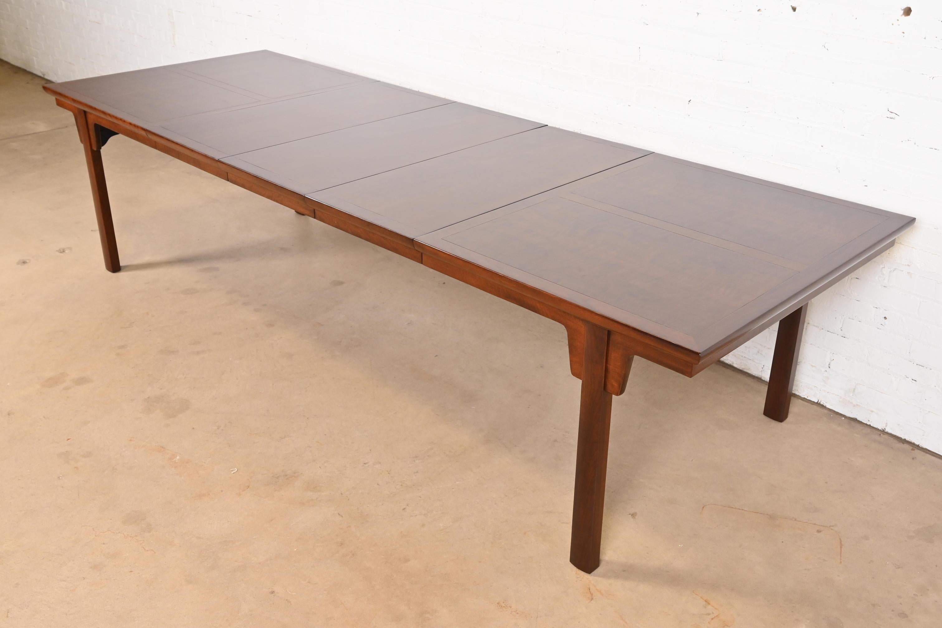 Ein atemberaubender Mid-Century Modern Hollywood Regency Esstisch mit Verlängerung

Von Michael Taylor für Baker Furniture

USA, ca. 1960er Jahre

Geschnitztes Nussbaumholz, mit wunderschöner Platte aus genopptem Nussbaumholz im Buchformat.

Maße: