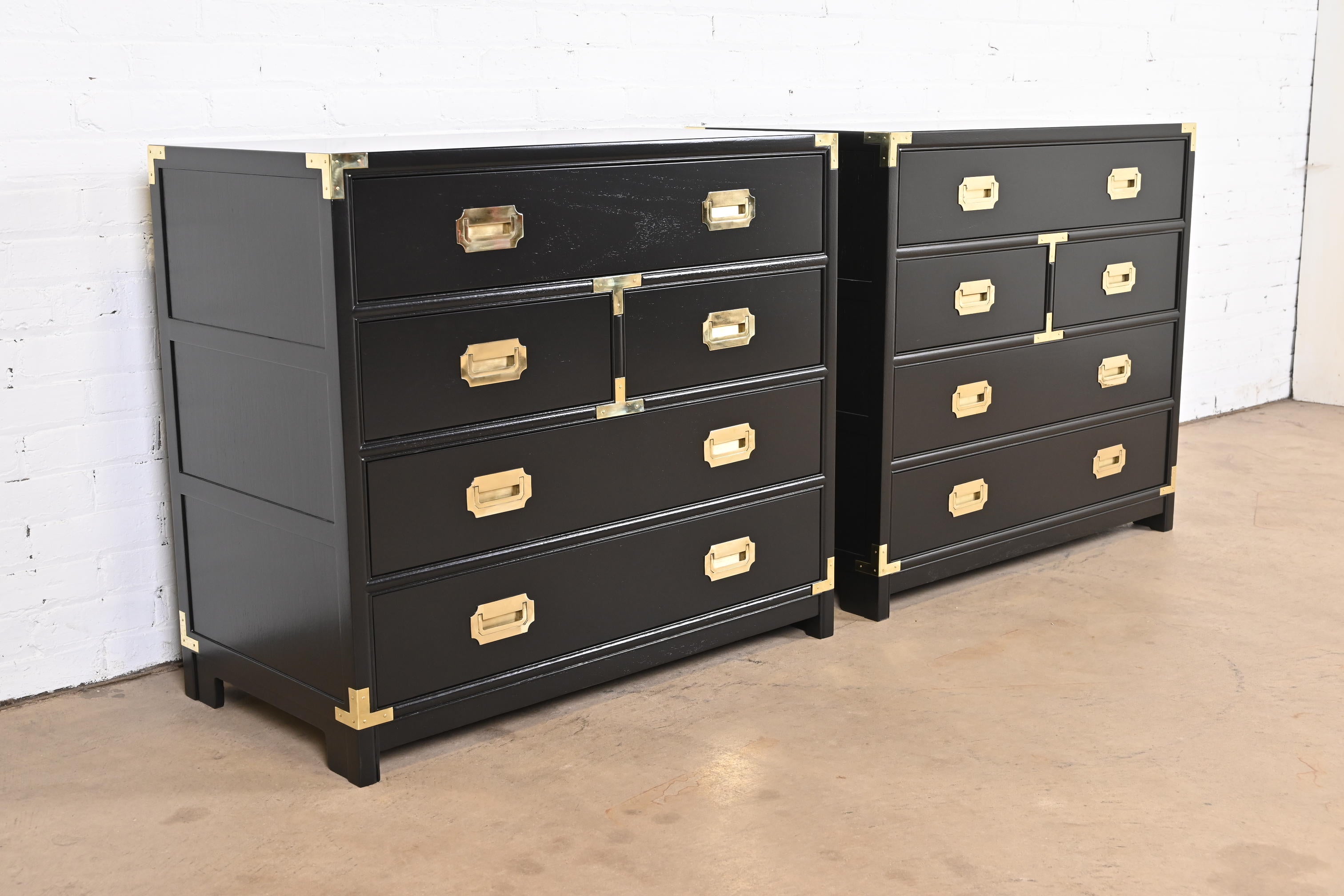 A stunning pair of Mid-Century Modern Hollywood Regency Campaign style five-drawer dressers or chests of drawers.

By Michael Taylor for Baker Furniture, 