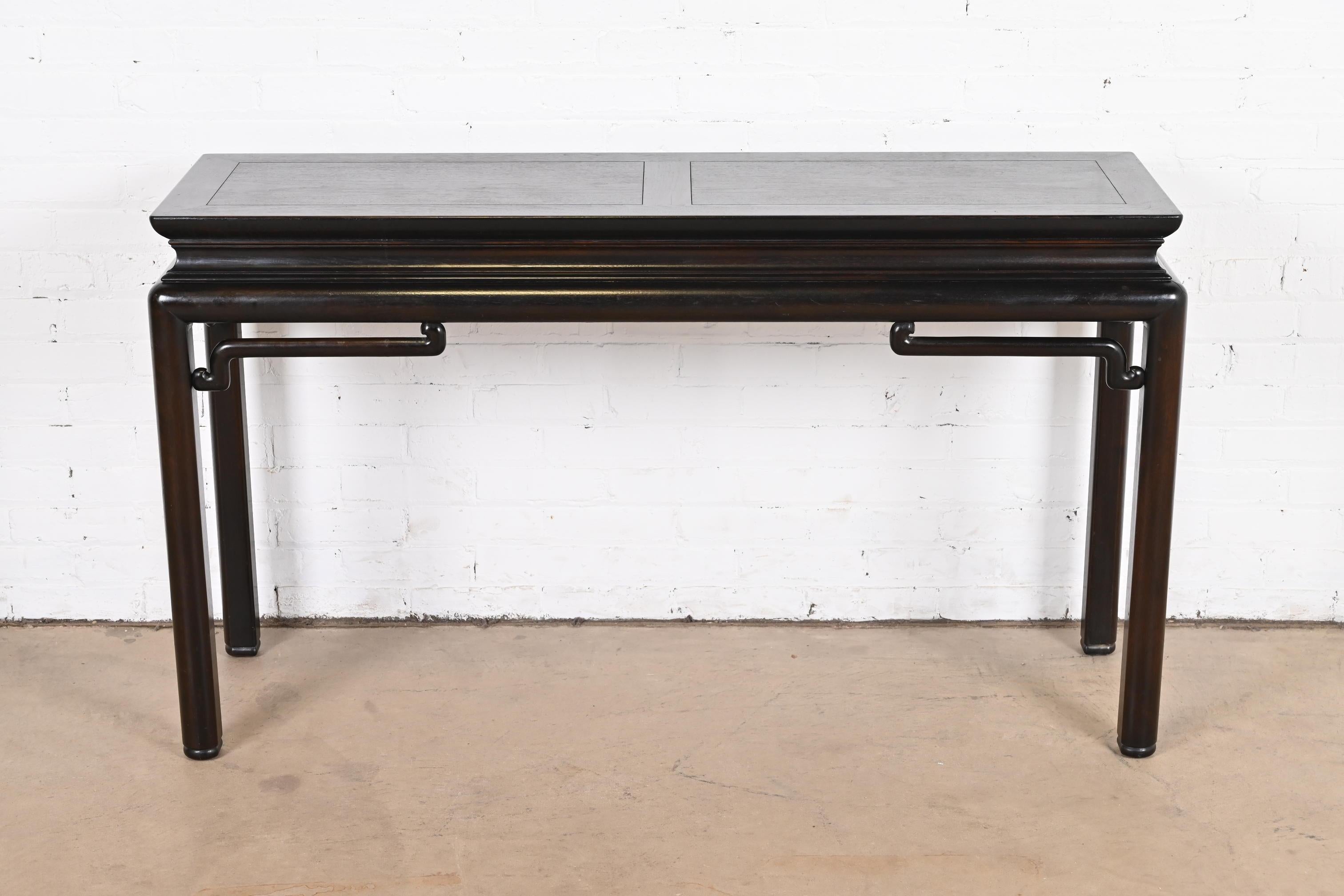 A gorgeous midcentury Hollywood Regency chinoiserie console table or sofa table

By Michael Taylor for Baker Furniture

USA, Circa 1960s

Carved ebonized walnut, with Asian influenced design.

Measures: 55