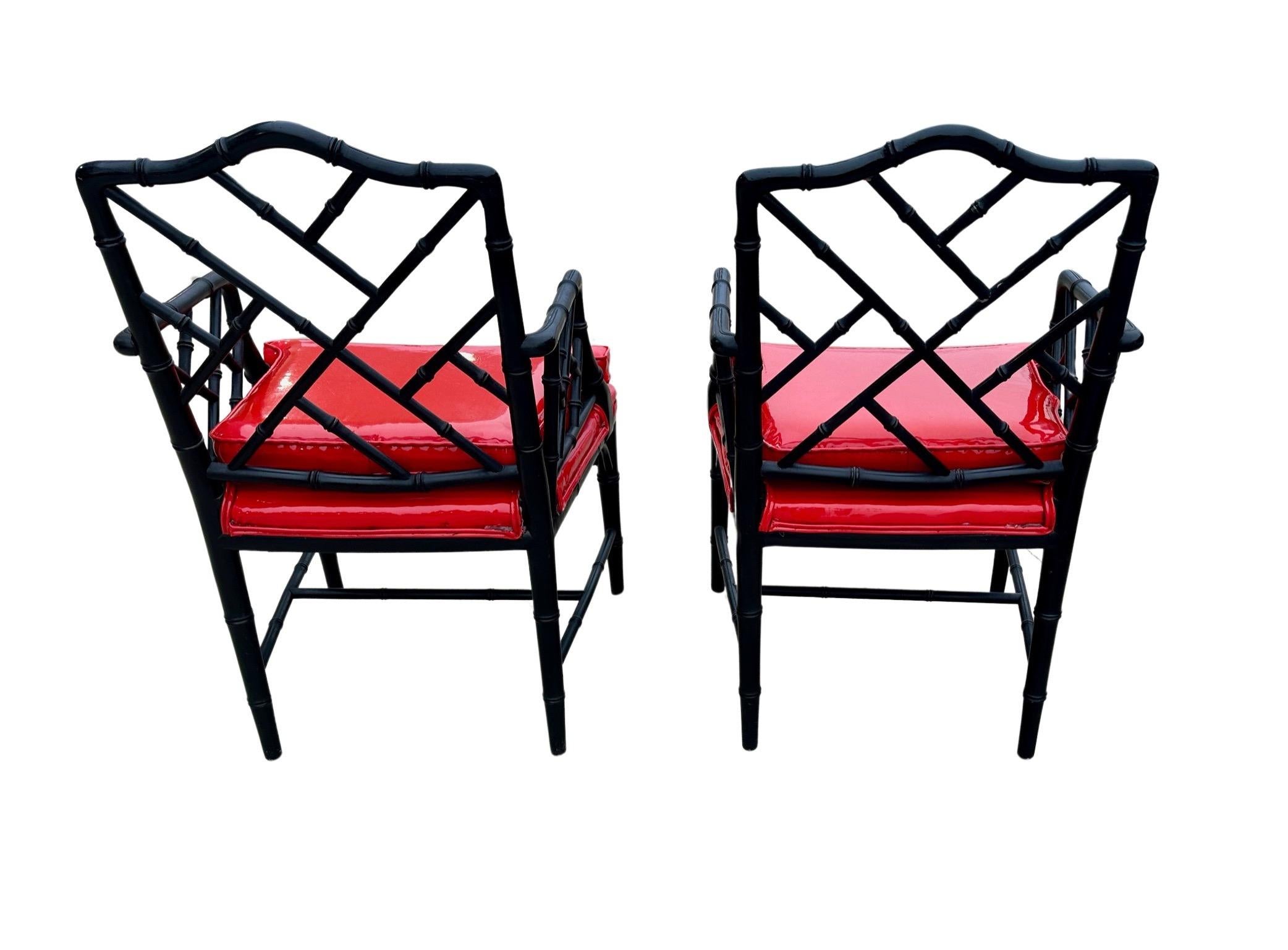 Pair of Michael Taylor for Baker faux bamboo Chinese Chippendale armchairs in black paint and red patent vinyl leather.  Stunning in color and timeless in shape!  The chairs are firm, sturdy and very comfortable as the seats are padded. They are