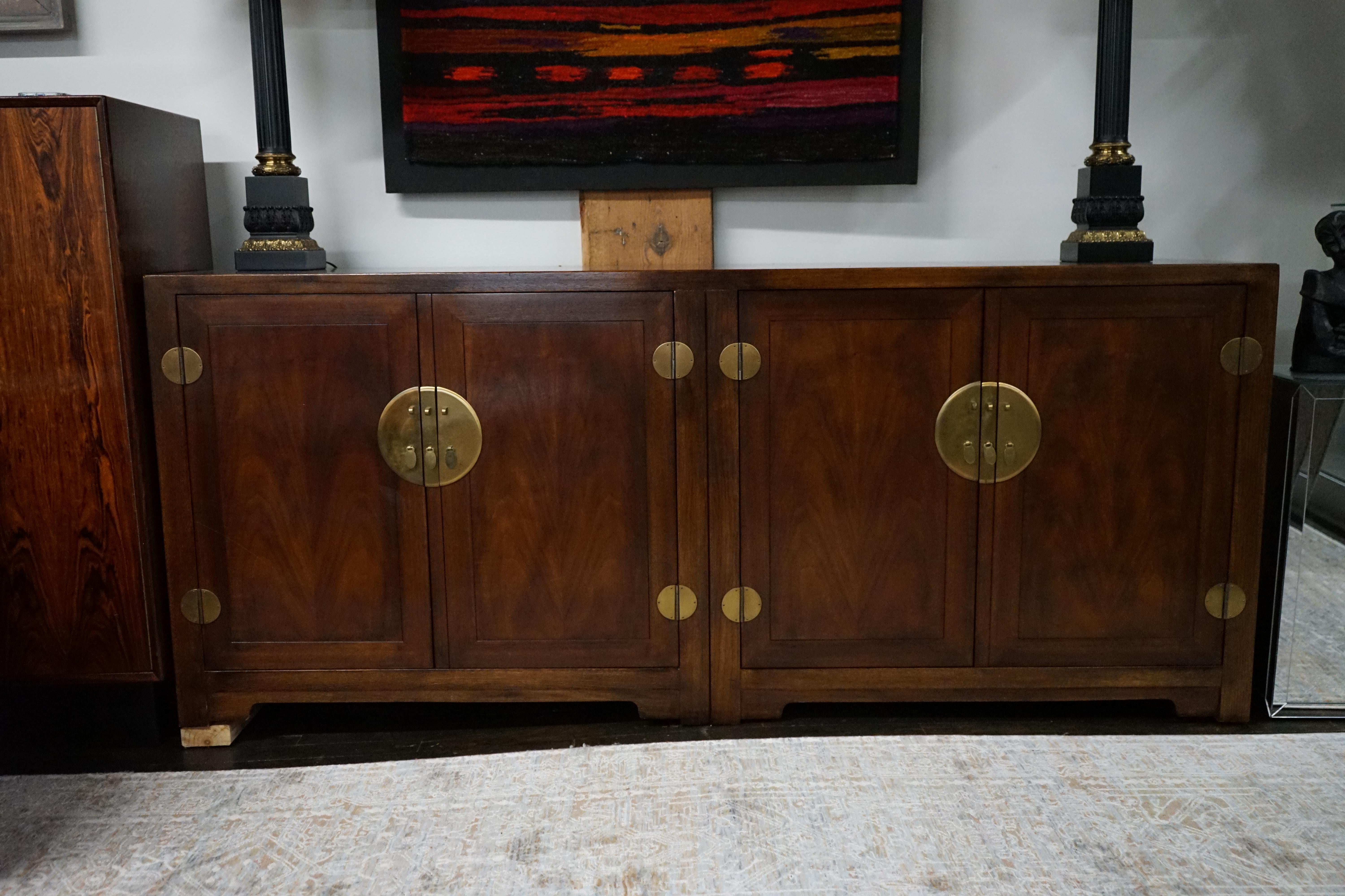 Mid-Century buffet designed by Michael Taylor for Baker Furniture.  This piece was from the Far East Collection (one of his most popular collections).  The case is in walnut and the hardware is brass.  There are 4 cabinet doors and behind each set