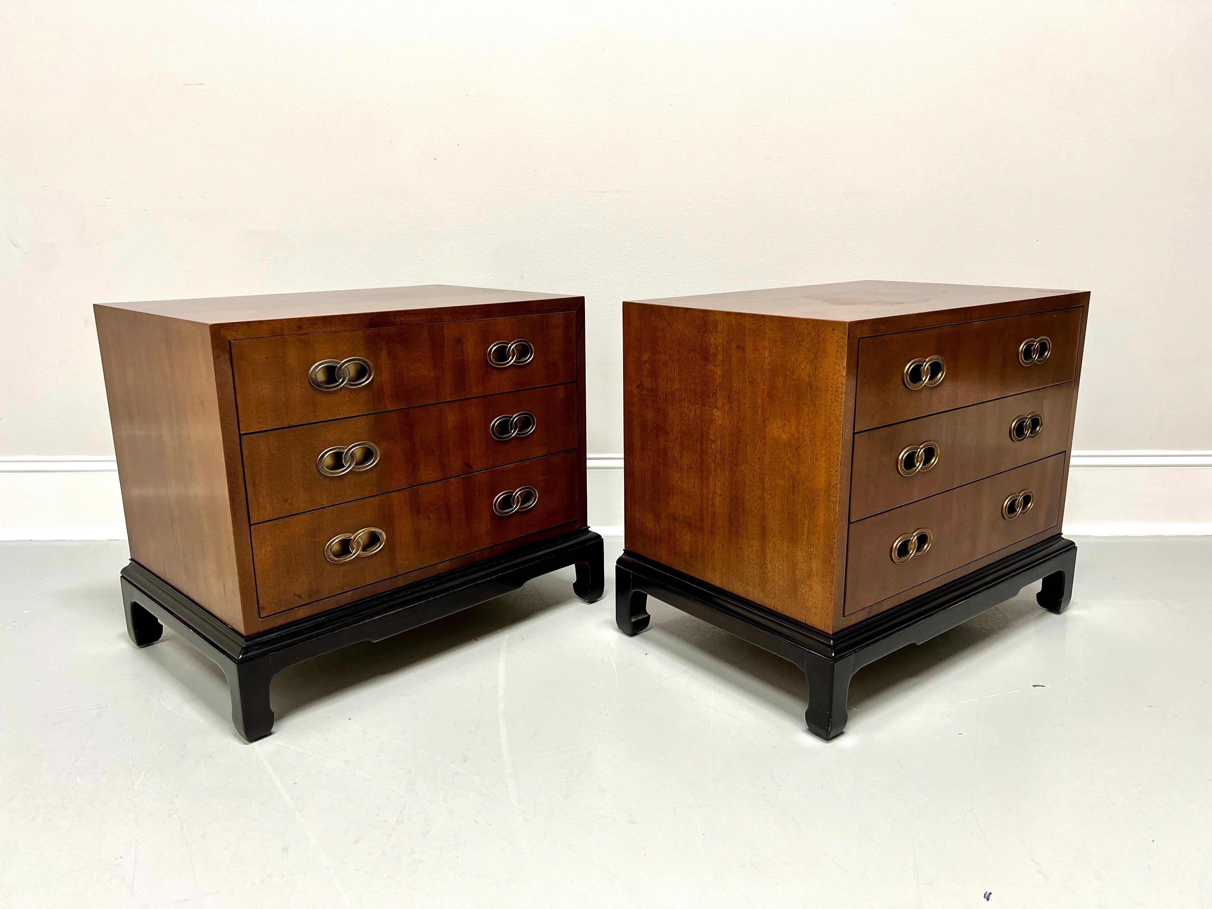 A pair of Asian inspired nightstands designed by Michael Taylor for Henredon. Mahogany with a slightly distressed finish, decorative brass hardware, square edge to top, Ming design black lacquered base with curved inward square legs. Features three