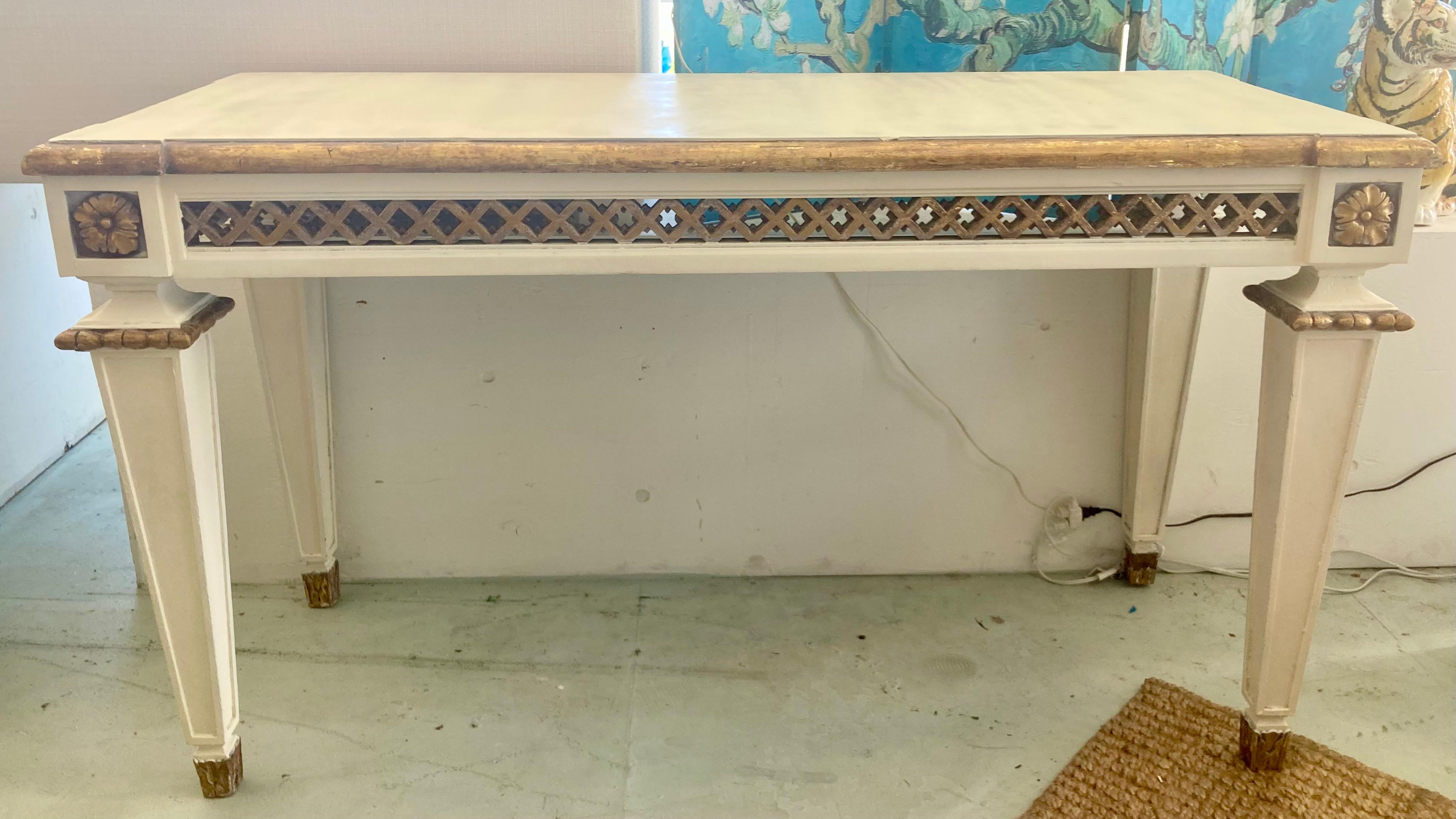 Incredible vintage Michael Taylor French style console in gilt and painted ivory finish. Beautiful finish combination. This is an older Michael Taylor item with age and use, but adds to the character. It has been touched up and painted over the