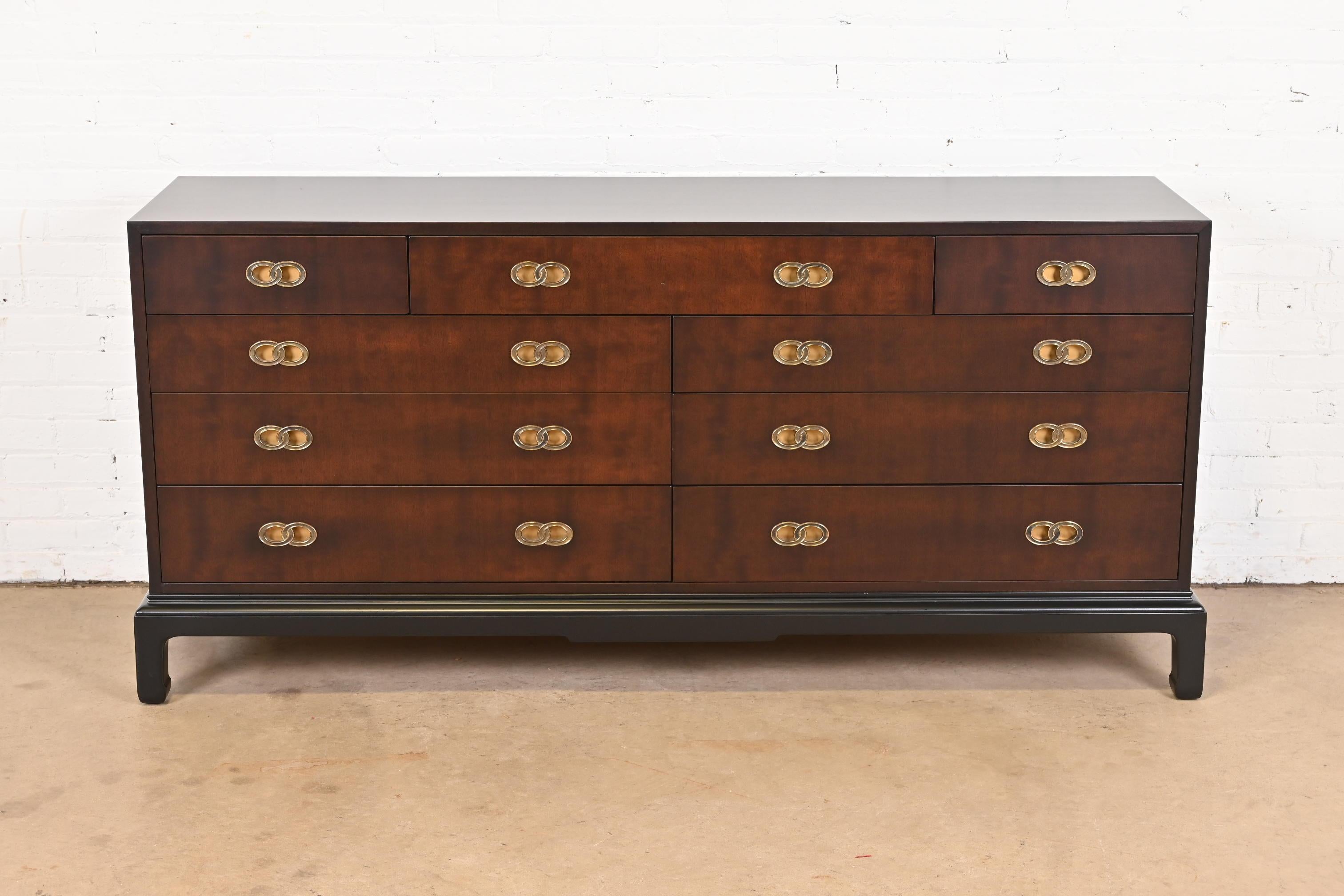 An exceptional mid-century modern Hollywood Regency Chinoiserie nine-drawer dresser or credenza

By Michael Taylor for Henredon

USA, Circa 1970s

Mahogany case, with black lacquered base and legs, and iconic brass double ring drawer