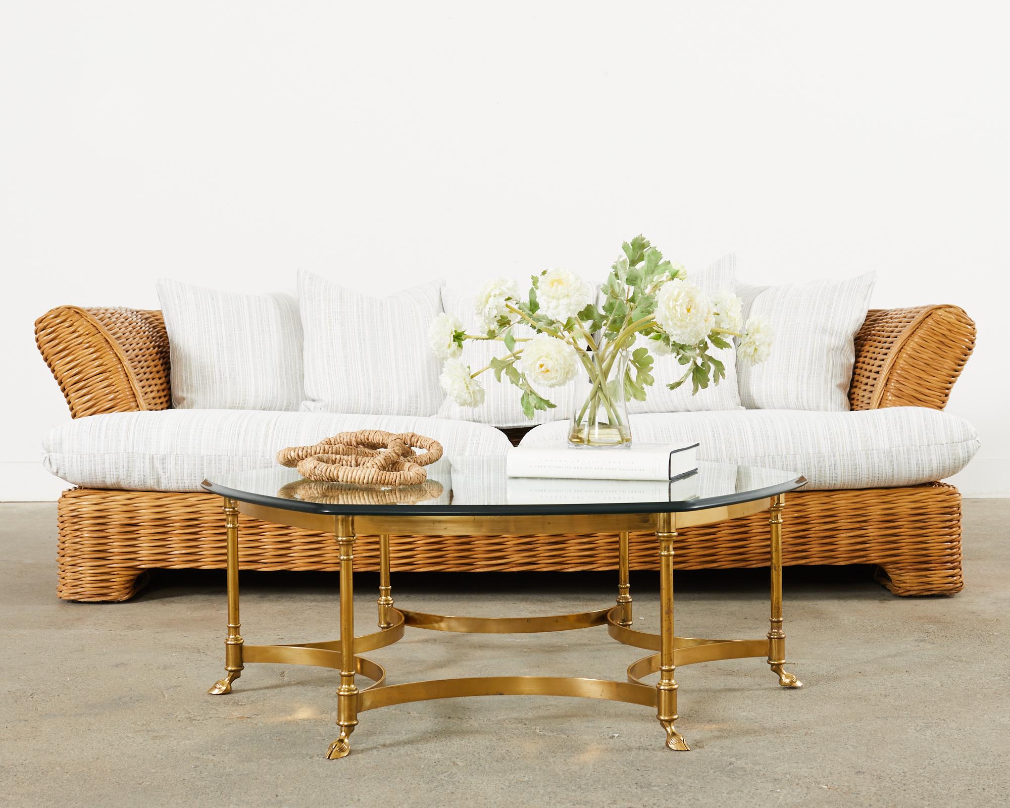 Large organic modern sofa crafted from thick pencil reed woven rattan in the California coastal manner and style of Michael Taylor. The sofa features a large frame with dramatic flared arms on each side. The frame has newly upholstered fabric