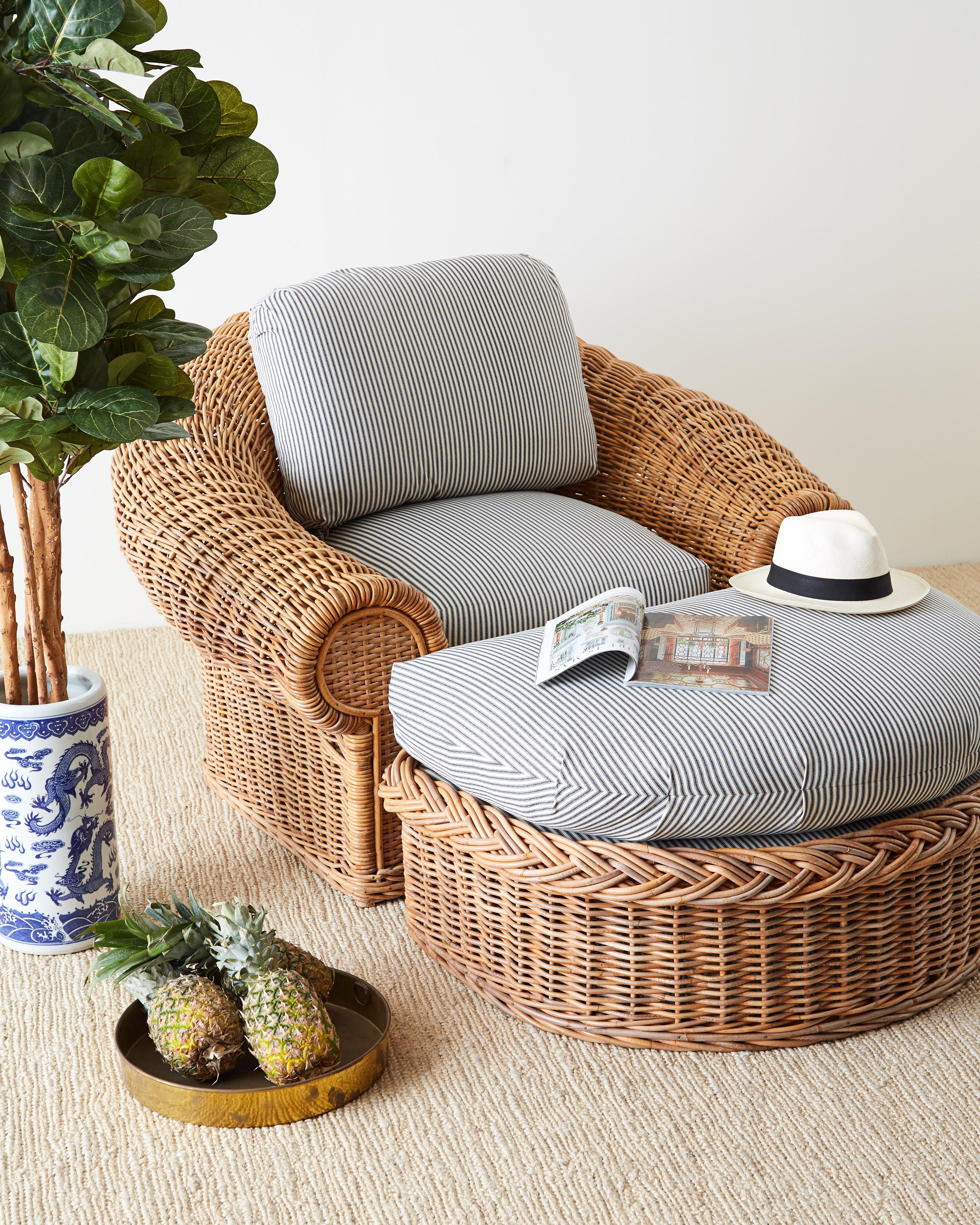 Large pair of stick wicker lounge chairs designed in the style of Michael Taylor. Two woven wicker covered frames and one demilune formed ottoman featuring newly upholstered French ticking stripe fabric in classic blue and white. These oversized