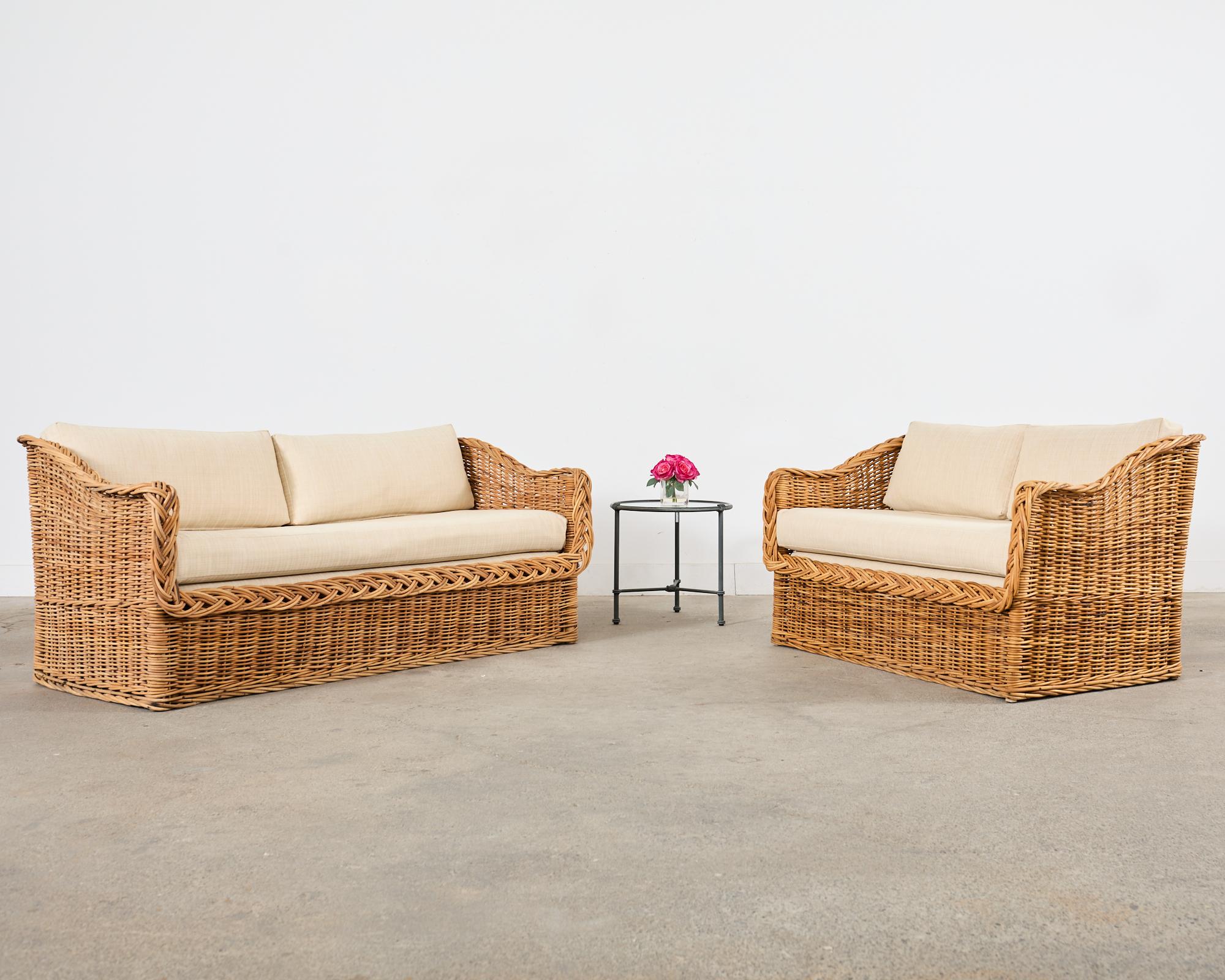 Organic modern rattan loveseat settee hand-crafted by the Wicker Works in Italy. Made in the California coastal manner and style of Michael Taylor designs. Known as the 