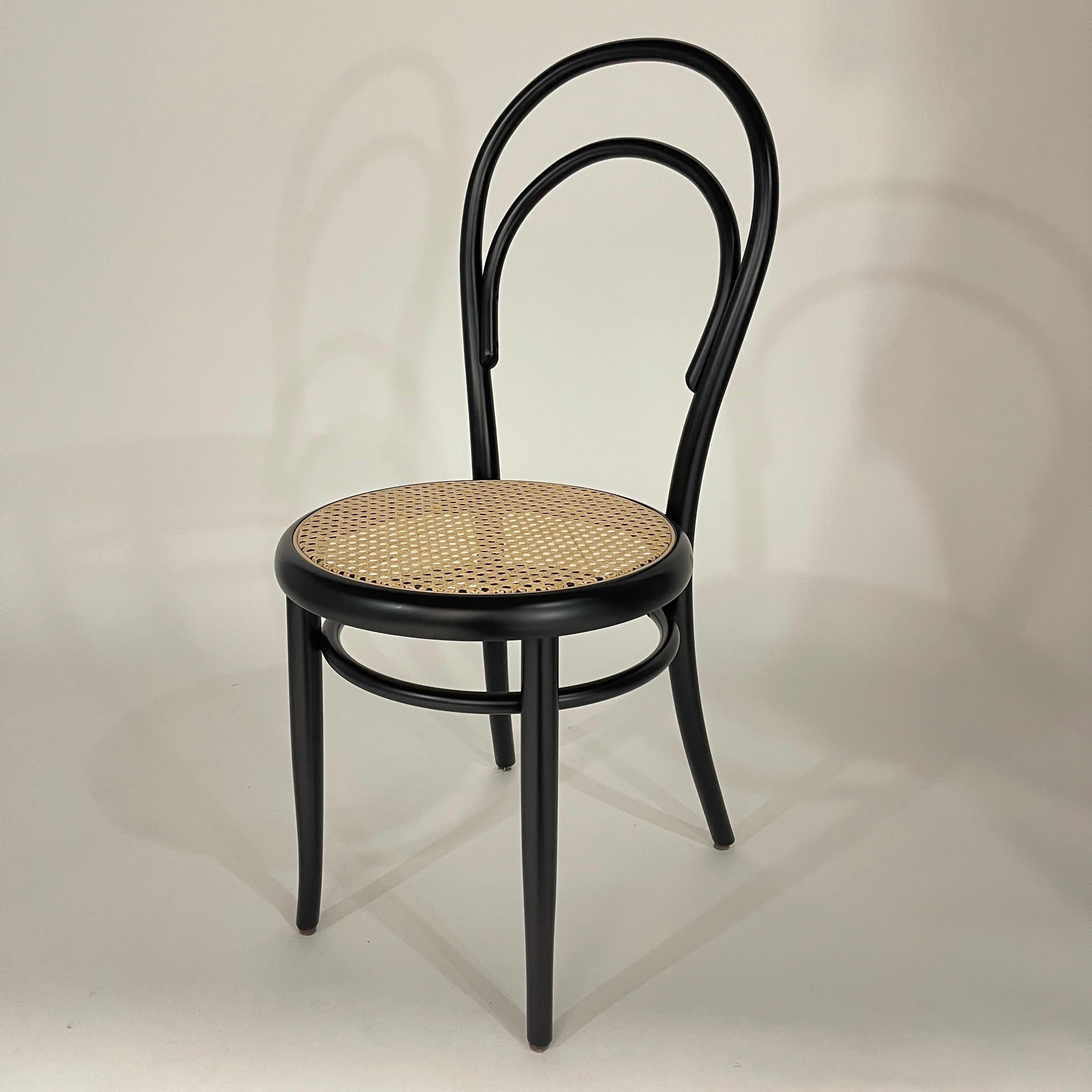 Iconic N. 14 Bistro dining chair or side chair designed by Michael Thonet, rendered in black painted beech bentwood frame with a woven wicker cain seat.  Austria