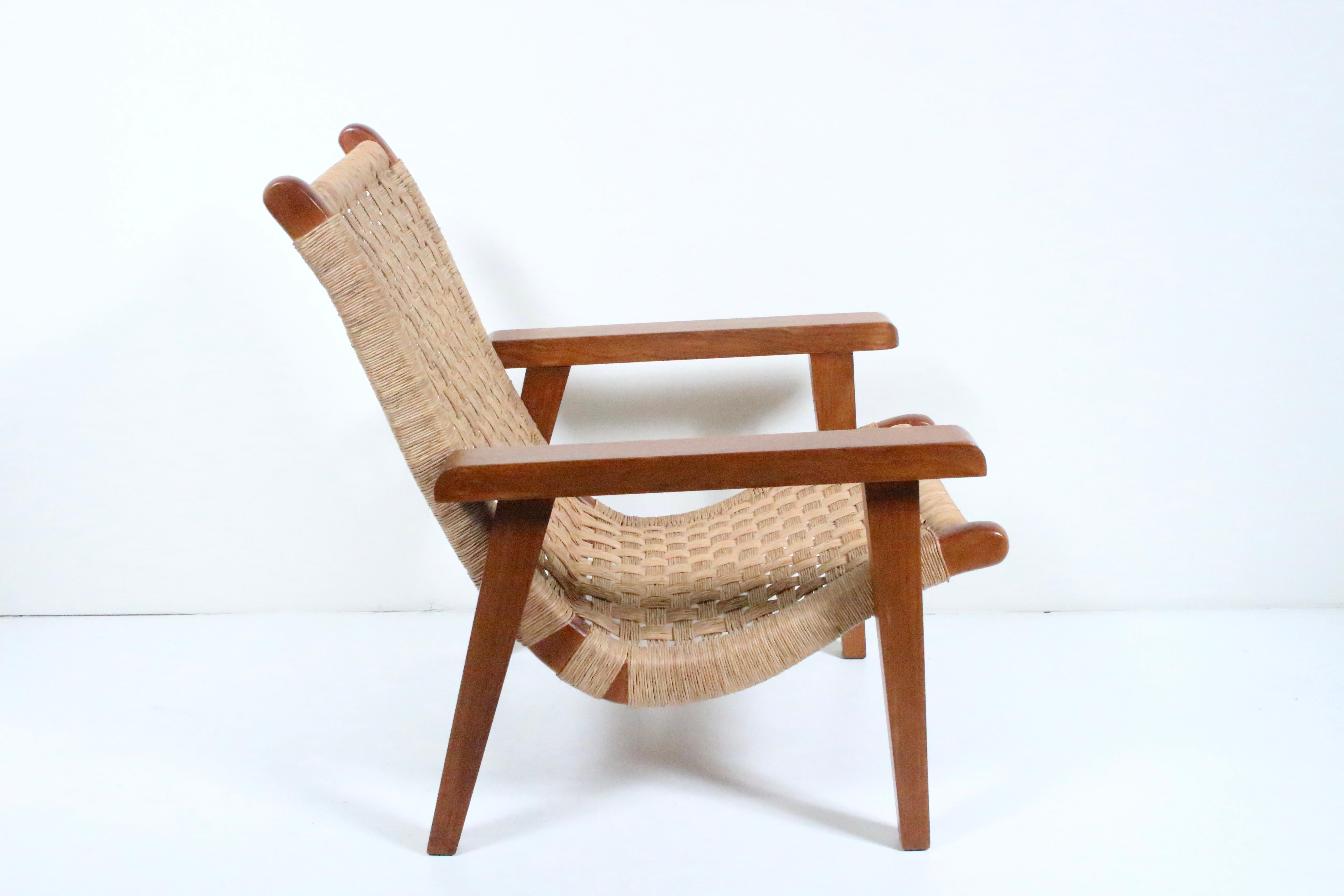 Mexican Modern Michael van Beuren Sessel aus Teakholz und geflochtenem Raffiabast. Mit einem robusten, funktionalen und komfortablen zweiteiligen Teakholzgestell, zwei Heringen zum Fixieren der Sitzfläche und einer mit Raffia umwickelten,
