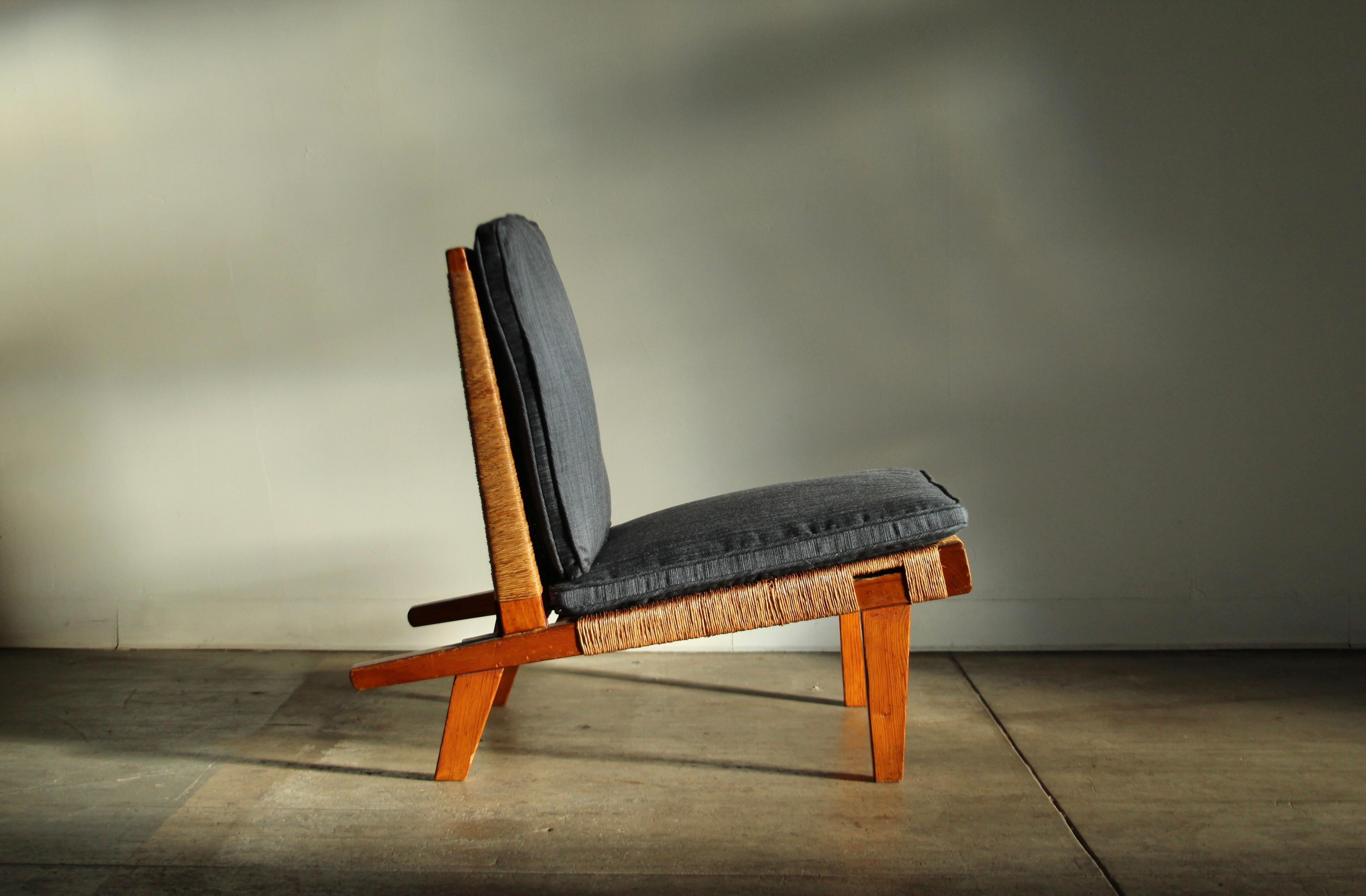An uncommon and stunning lounge chair designed by American Bauhaus designer Michael van Beuren in Mexico in the 1940s. Warm pine frame with original handwoven palm fiber seat and back. Hand forged iron bracket on back with original flathead screws.
