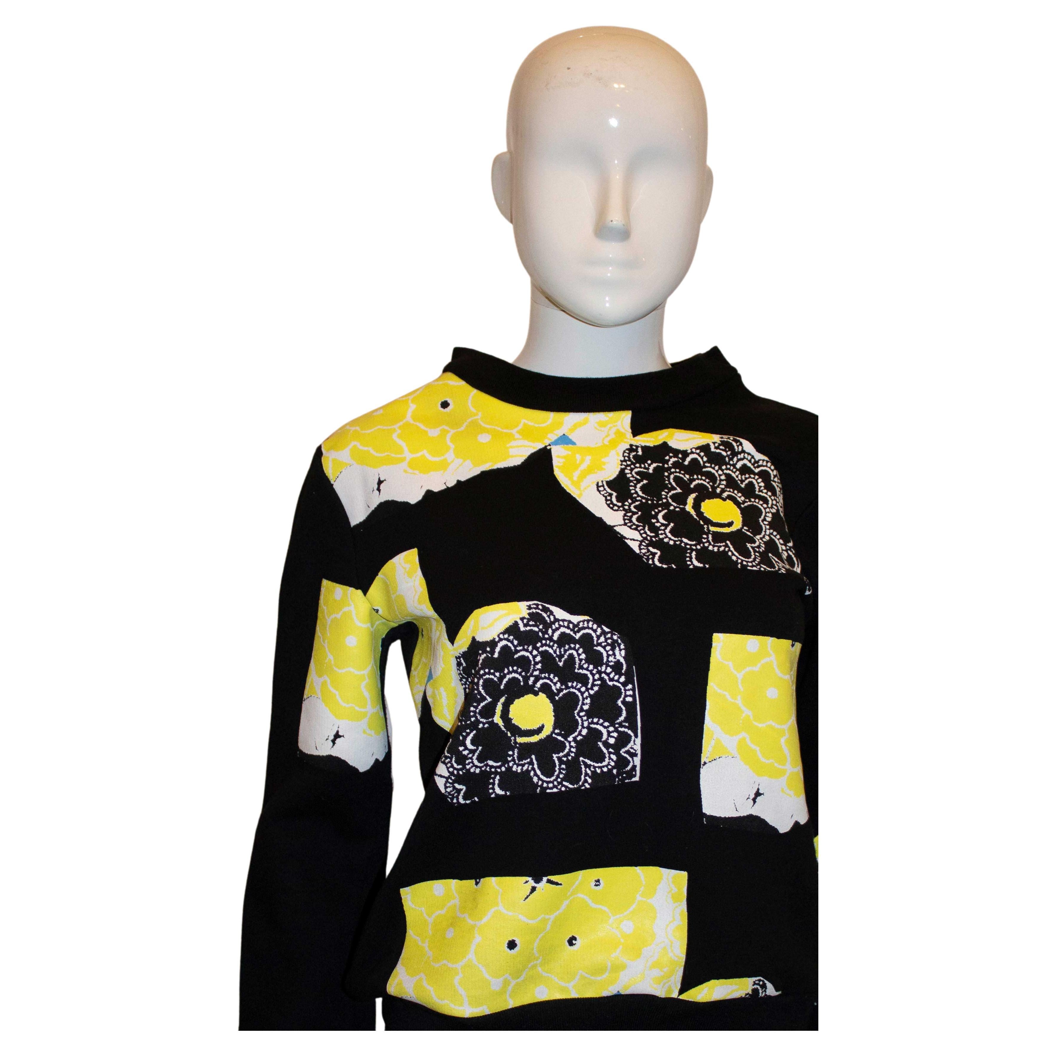 A colourful and easy to wear sweatshirt by Michael van der Ham. The top has a black background with a yellow, white and blue design. Size 8 Measurements: Bust up to 37'', length 22''