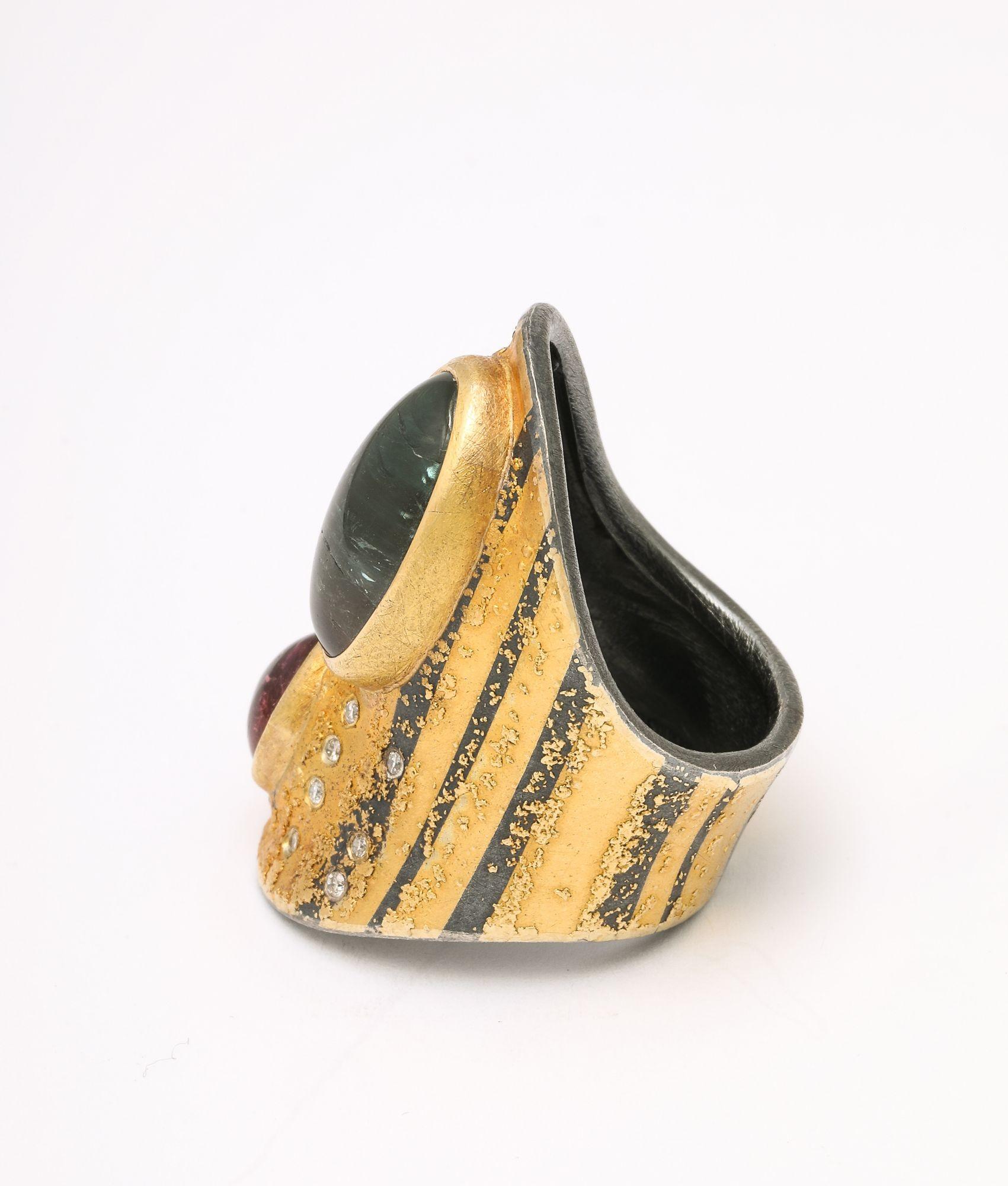 A beautiful wearable ring that moves beyond design becoming art. A gold body lined with silver and platinum hold a tourmaline and amethyst stones with a constellation of diamonds surrounding them. A unique earlier work by designer Michael Zobel from