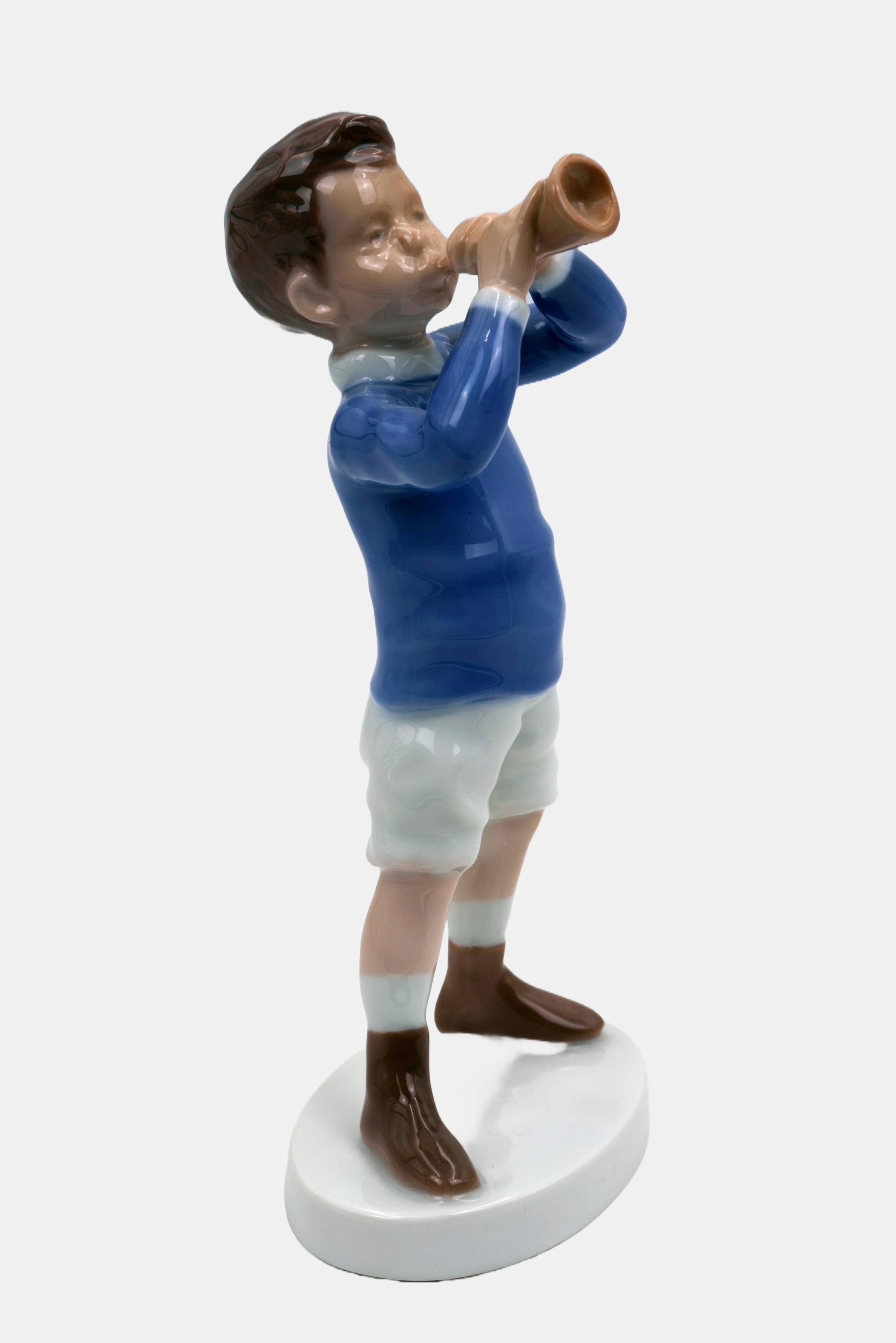 Michaela Ahlmann, ragazzo in piedi con tromba, prodotto tra il 1970 e il 1982, modello numero 1792, prima scelta. Porcellana con pittura sottosmalto. 18,5 cm (altezza) x 8 cm (lunghezza) x 7 cm (profondità). Con le iniziali dell'artista 