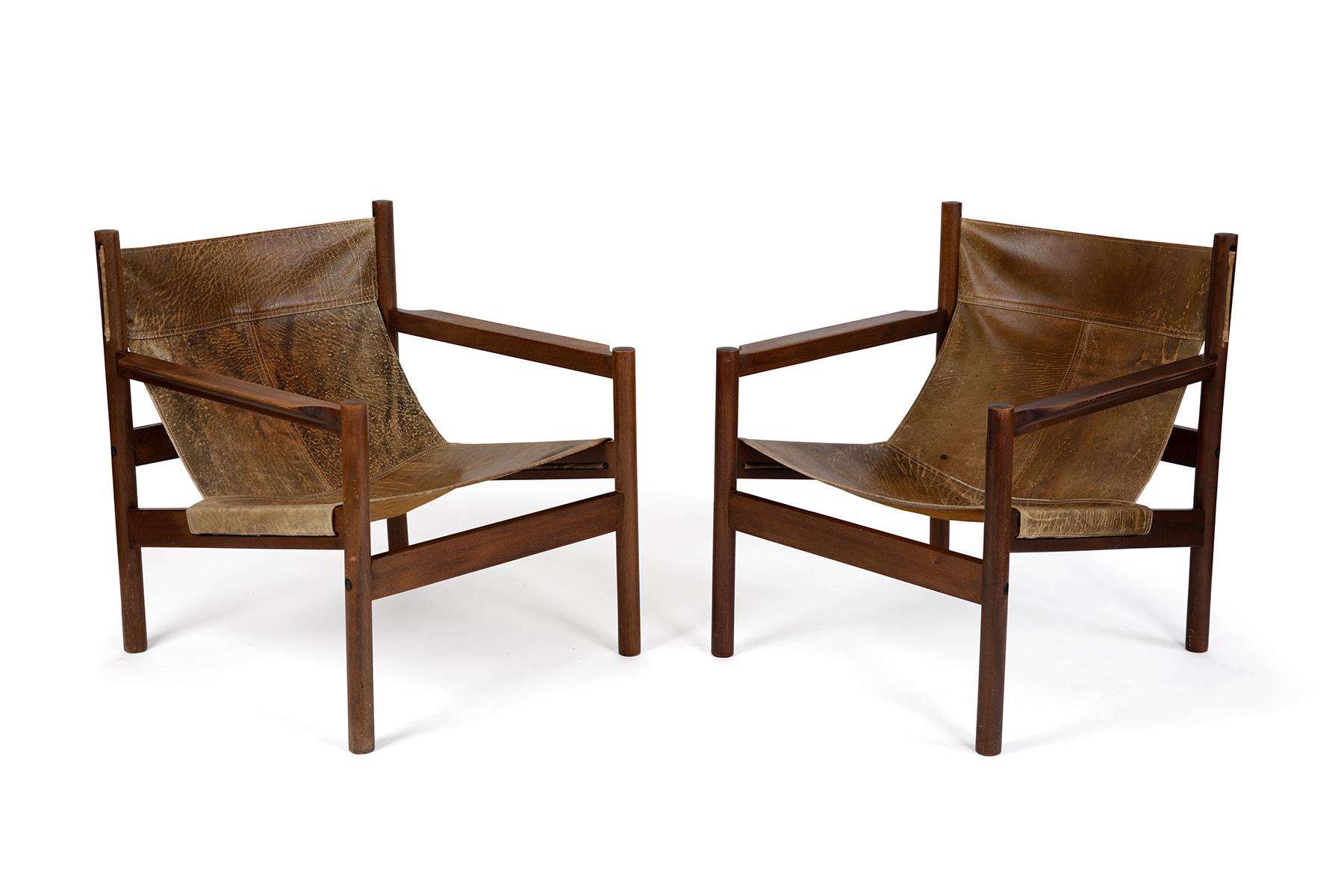 Rare Michel Arnoult wood and patinated leather sling style lounge chairs from Brazil. The leather on the back of one chair still sports the branding mark from the cowhide. Price listed is for the pair.