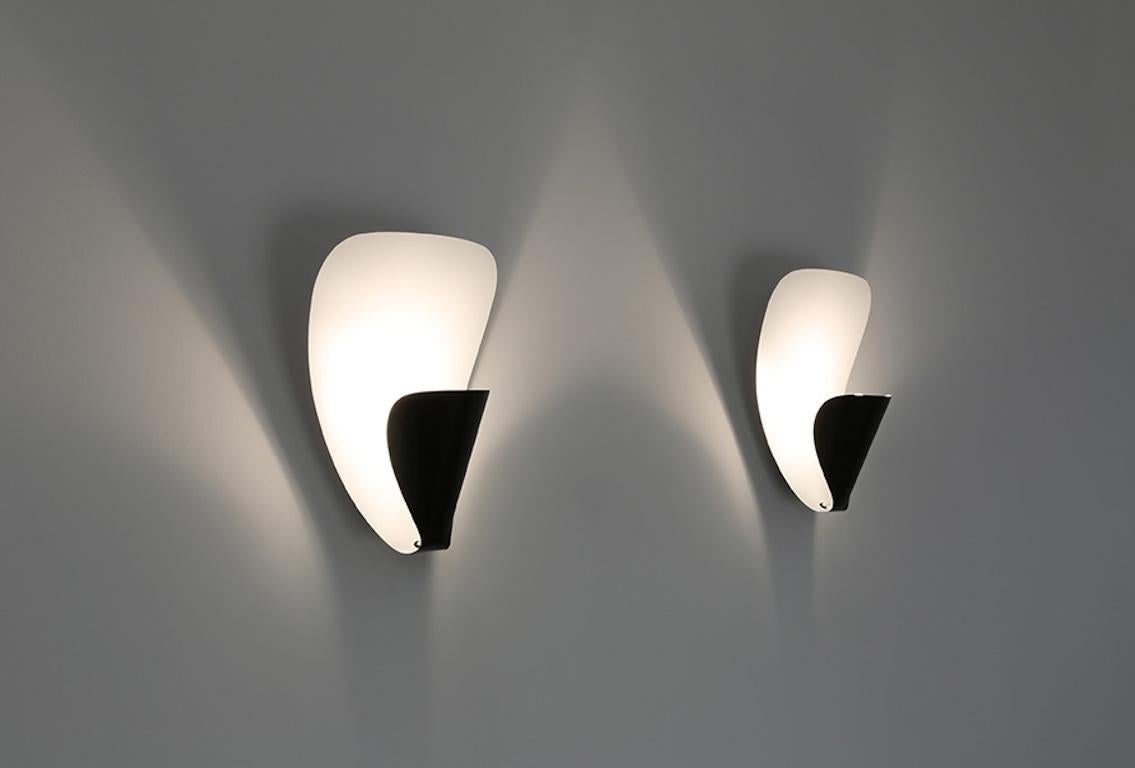 Si tratta di un design semplice, realizzato con eleganza e con curve sottili. Il bulbo viene avvolto e nascosto alla vista mentre la luce viene proiettata all'esterno. La lampada è realizzata con un foglio di alluminio smaltato.

Progettato