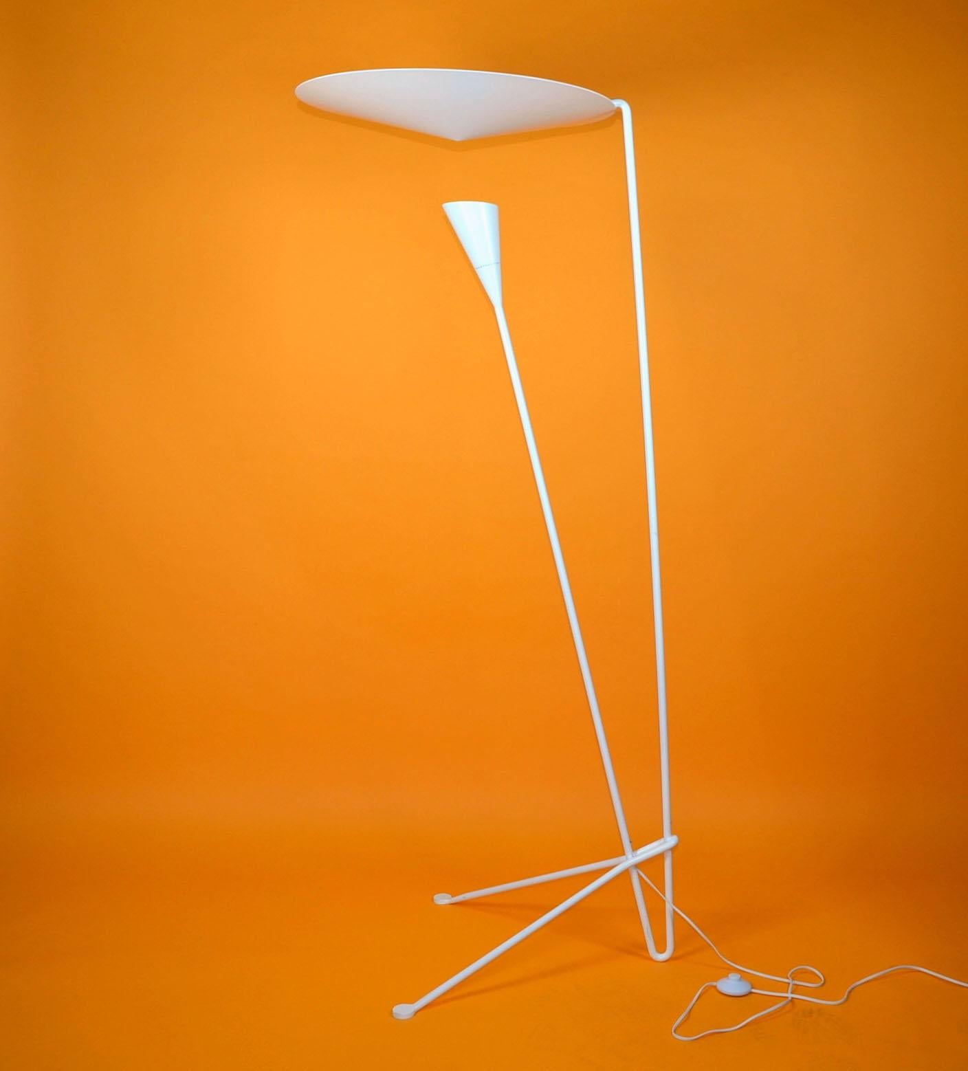 This Michel Buffet lamp's signatures include dynamic lines and an innovative means of dispersing light. Light shines on the conical disc above from the shade below and is reflected out.

This lamp comes in black and white.

Originally designed in