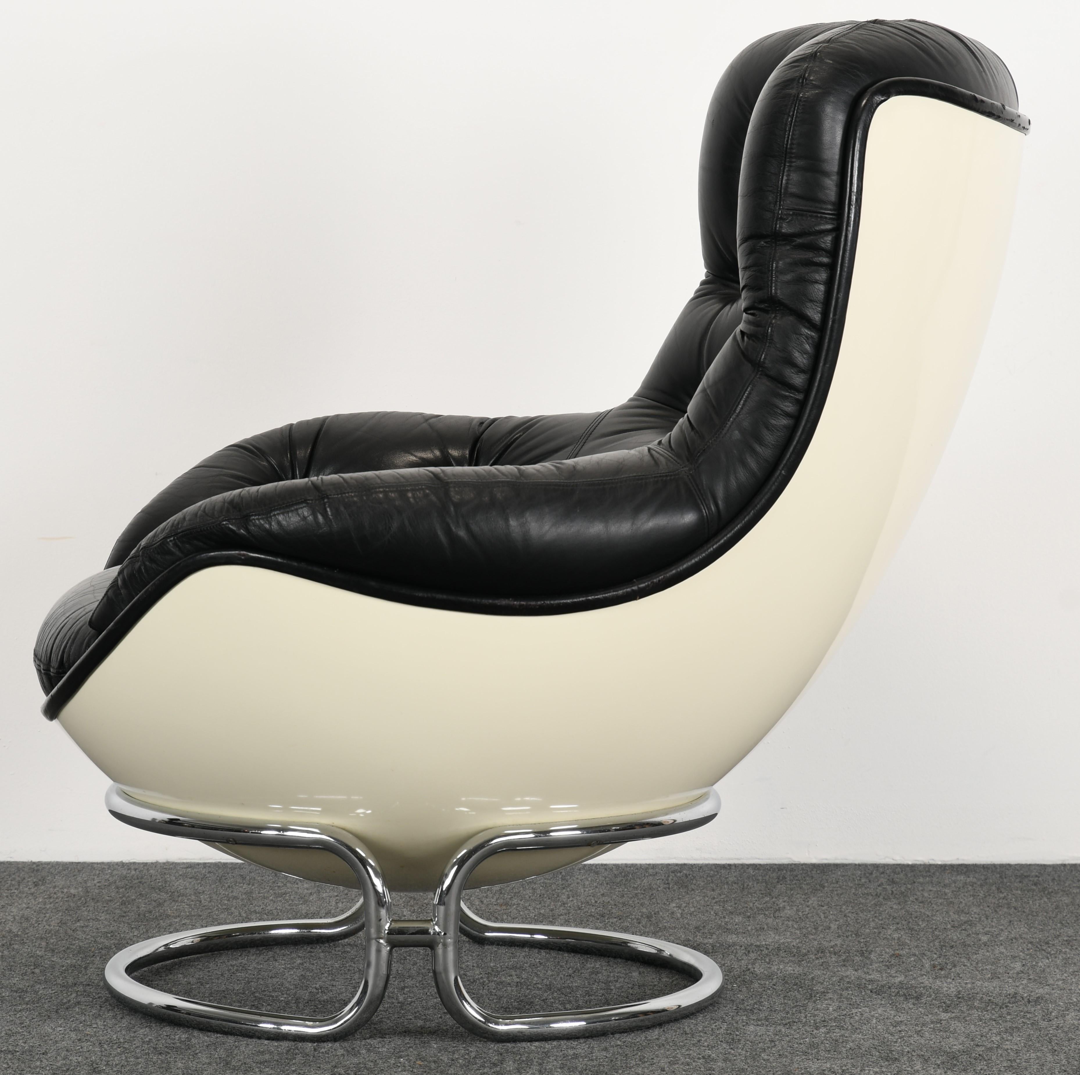 A modernist armchair designed by Michel Cadestin for French Furniture Manufacturer, Airborne, 1970s. This is a great lounge chair with a white molded fiberglass shell and chrome base. This chair has the original leather showing some wear to edges