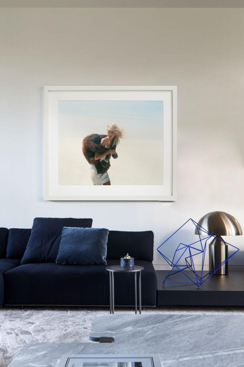 Blondes Modell mit einem Affen auf dem Rücken, der in der Wüste steht. Fotografiert von Michel Comte für seine Serie 'Beauty & Beast'.

Alle Drucke sind in limitierter Auflage erhältlich. Erhältlich in mehreren Größen. Hochwertige Einrahmung auf
