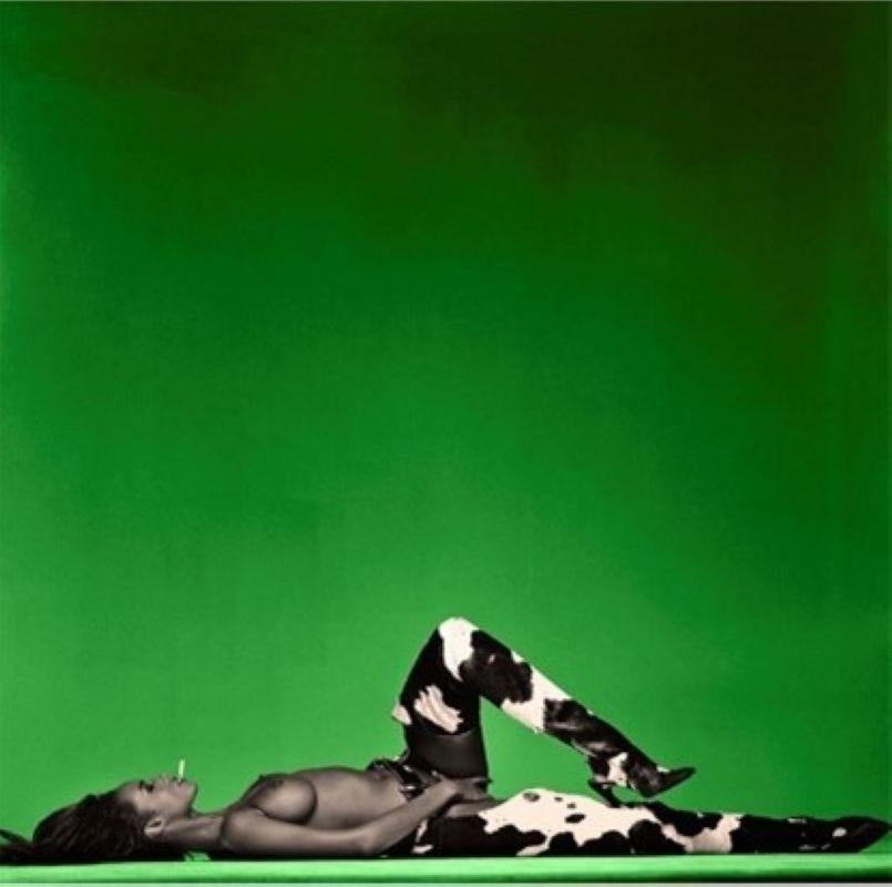 Iman - the supermodel in boots naked in front of a green background 