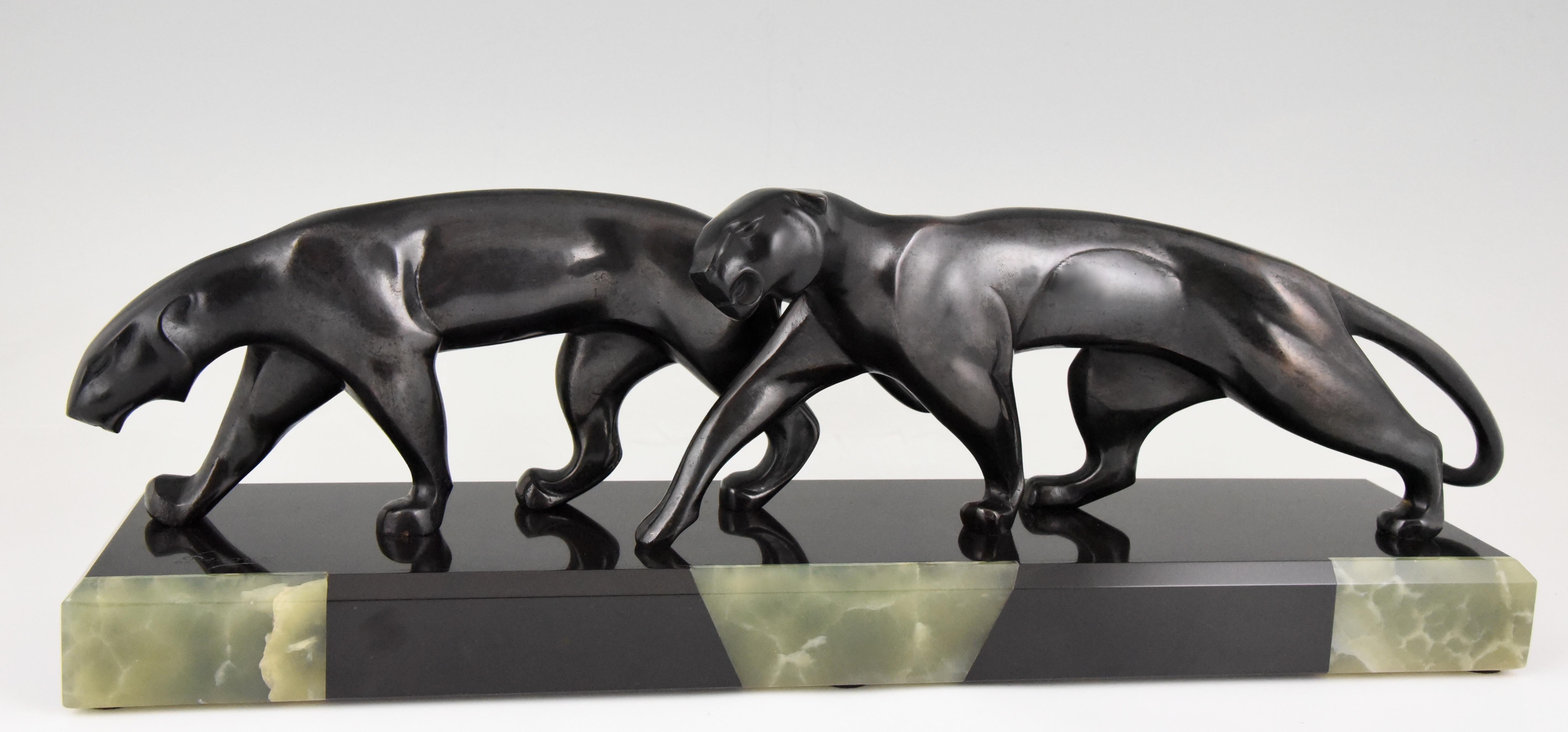 Sculpture Art déco en bronze représentant deux panthères, réalisée par l'artiste français Michel Decoux (1837-1924). Le bronze a une belle patine foncée et repose sur un socle en onyx et noir belge. 

Ce modèle est illustré à la page 294 du livre