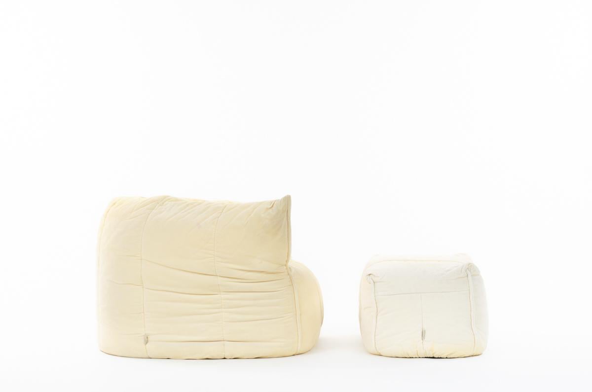 Beautiful and rare set of Michel ducaroy armchair and footstool, produced by Ligne Roset in 1980 named Brigantin. 
Composed of a foam structure cover by a pale yellow fabric with nice patina. Fantastic and enveloping design. 
publisher label on
