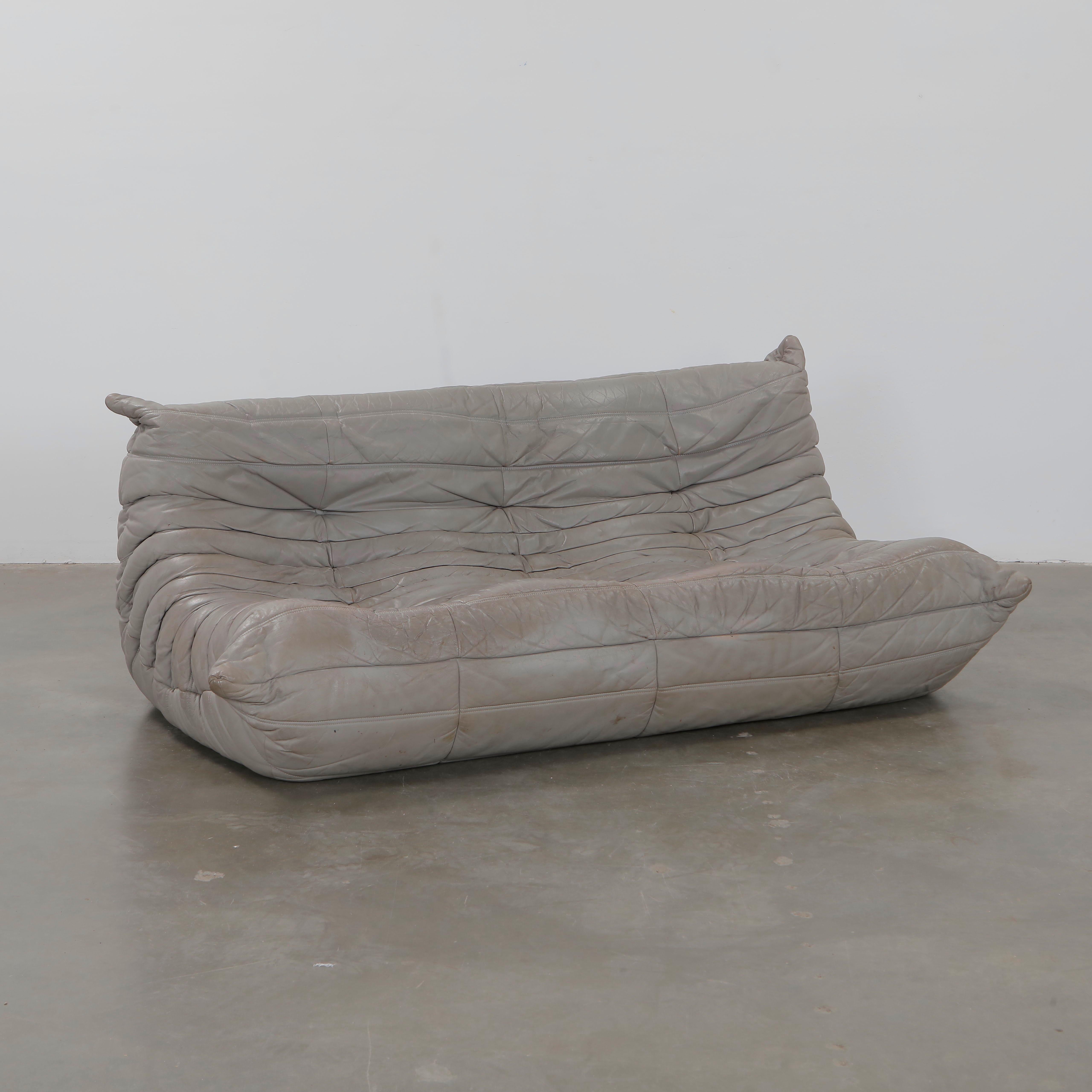 A vintage three-seater Togo sofa by Michel Ducaroy for Ligne Roset, upholstered in supple grey leather. With its low profile and organic form, this piece exemplifies the radical design ethos of 1970s France, still lauded for its comfort and style.