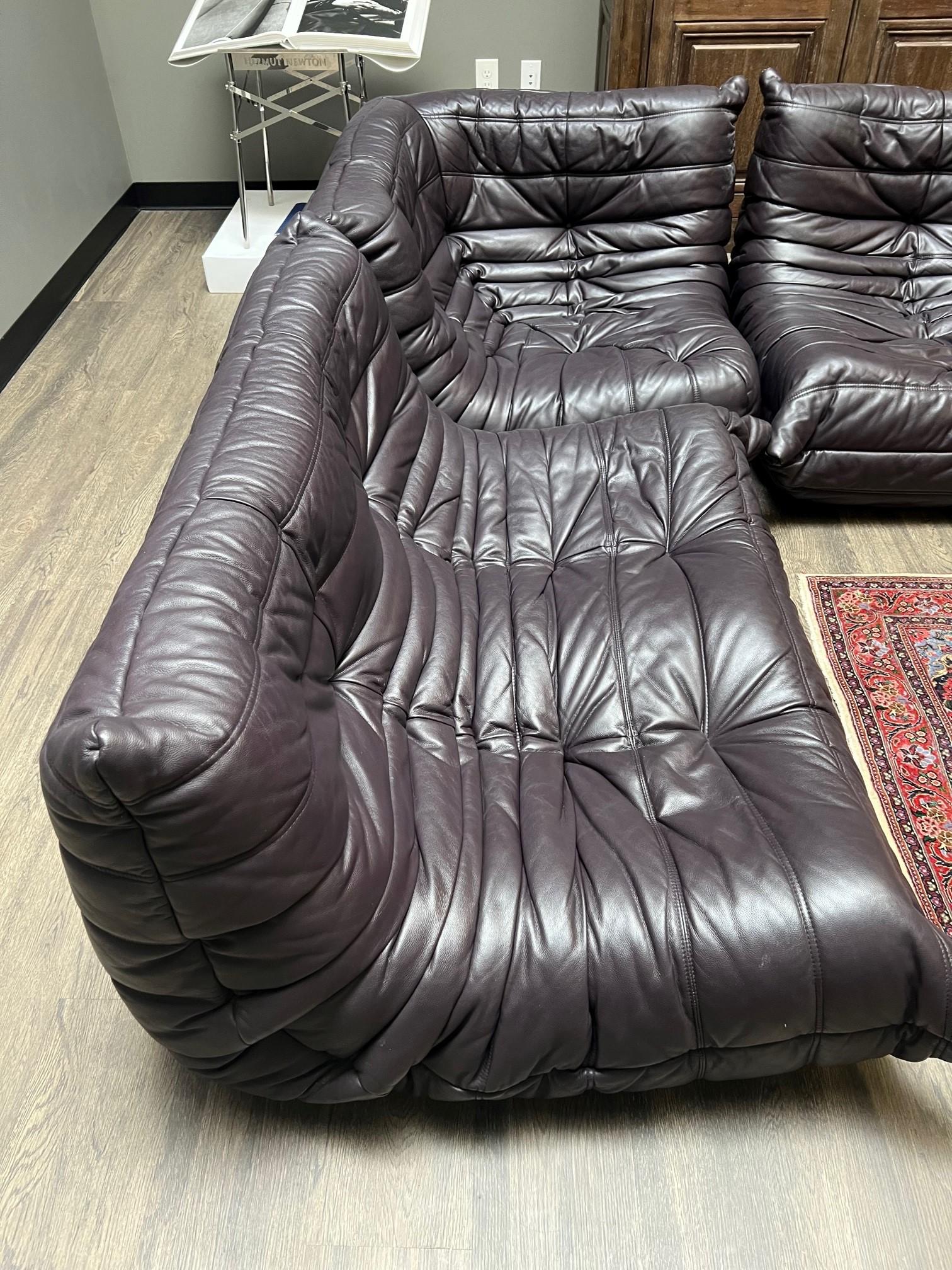 This wonderful Michel Ducaroy for Ligne Roset, 'Togo' Sectional Sofa is has deep and rich plum color.

This particular one is a Three-piece 'Togo' sectional sofa, circa from the 1970s

The sectional is made with Leather and Polyurethane foam and