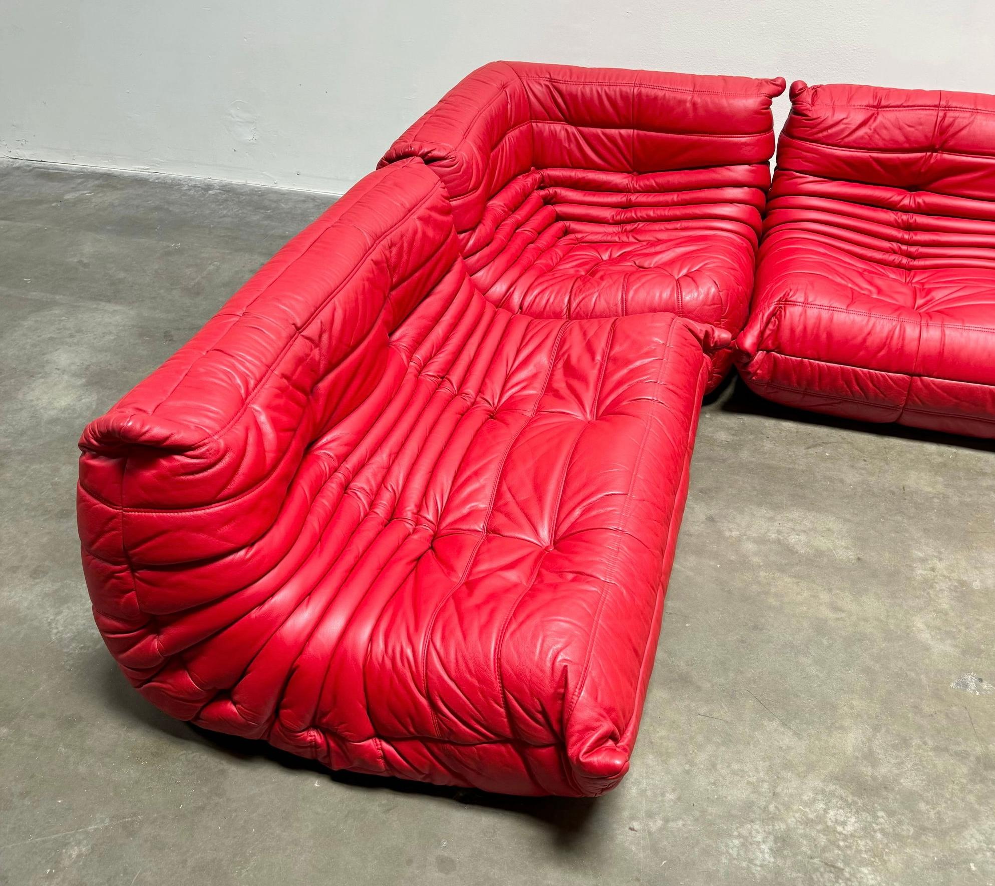 A stunning red leather Togo sectional by Michel Ducaroy for Ligne Roset. It is all tagged properly and in good condition with supple leather and free of rips or tears. There are a few marks to the leather. The depth of the three pieces is 38 inches.